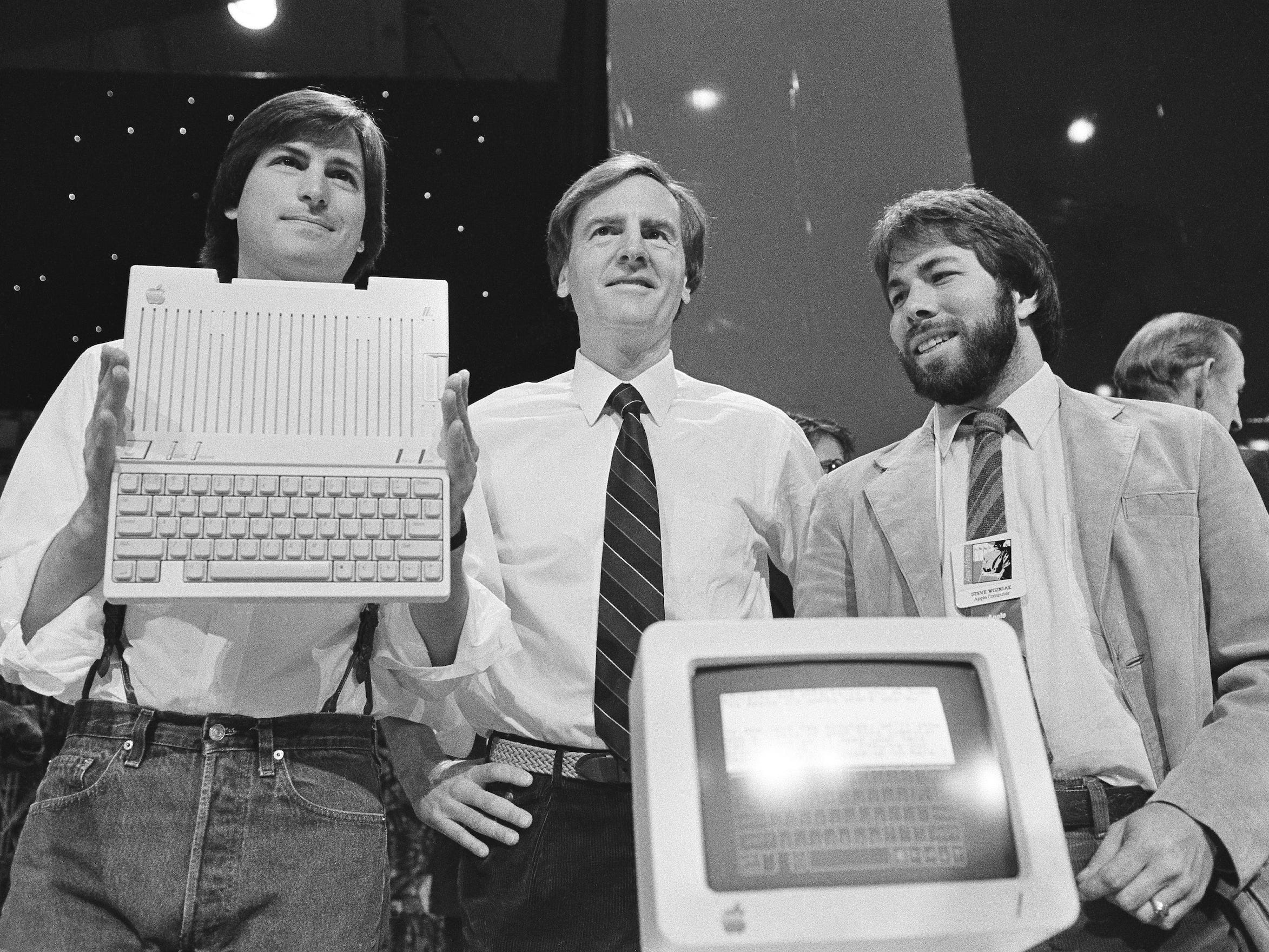 Steve Jobs (links), John Sculley (Mitte) und Steve Wozniak enthüllen 1984 in San Francisco den neuen Apple II-Computer.