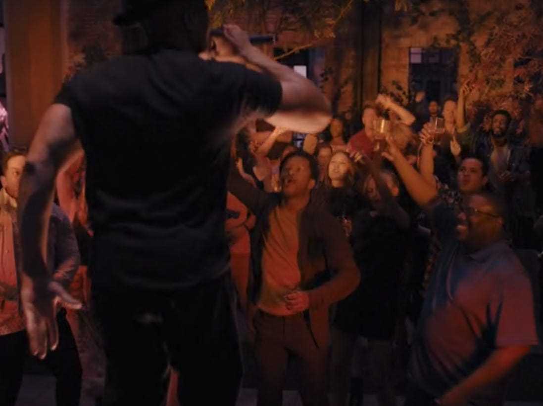 eine dramatisierung einer lauf-dmc-performance in episode 4 von wecrahsed, ein mann, der vor einer kleinen menschenmenge steht und auftritt