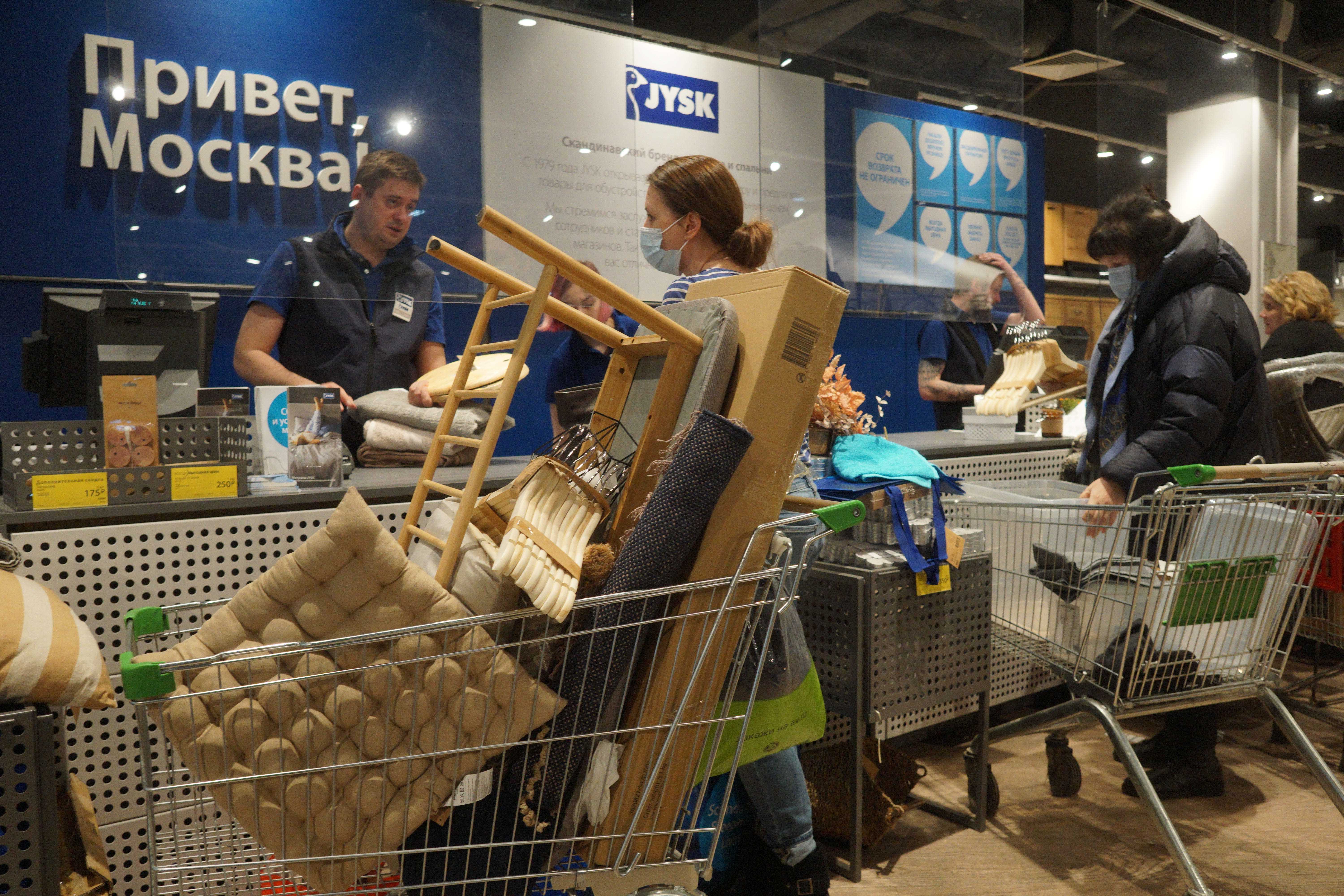 Menschen stehen Schlange, um ihre letzten Einkäufe in einem JYSK-Geschäft in Moskau, Russland, zu tätigen.