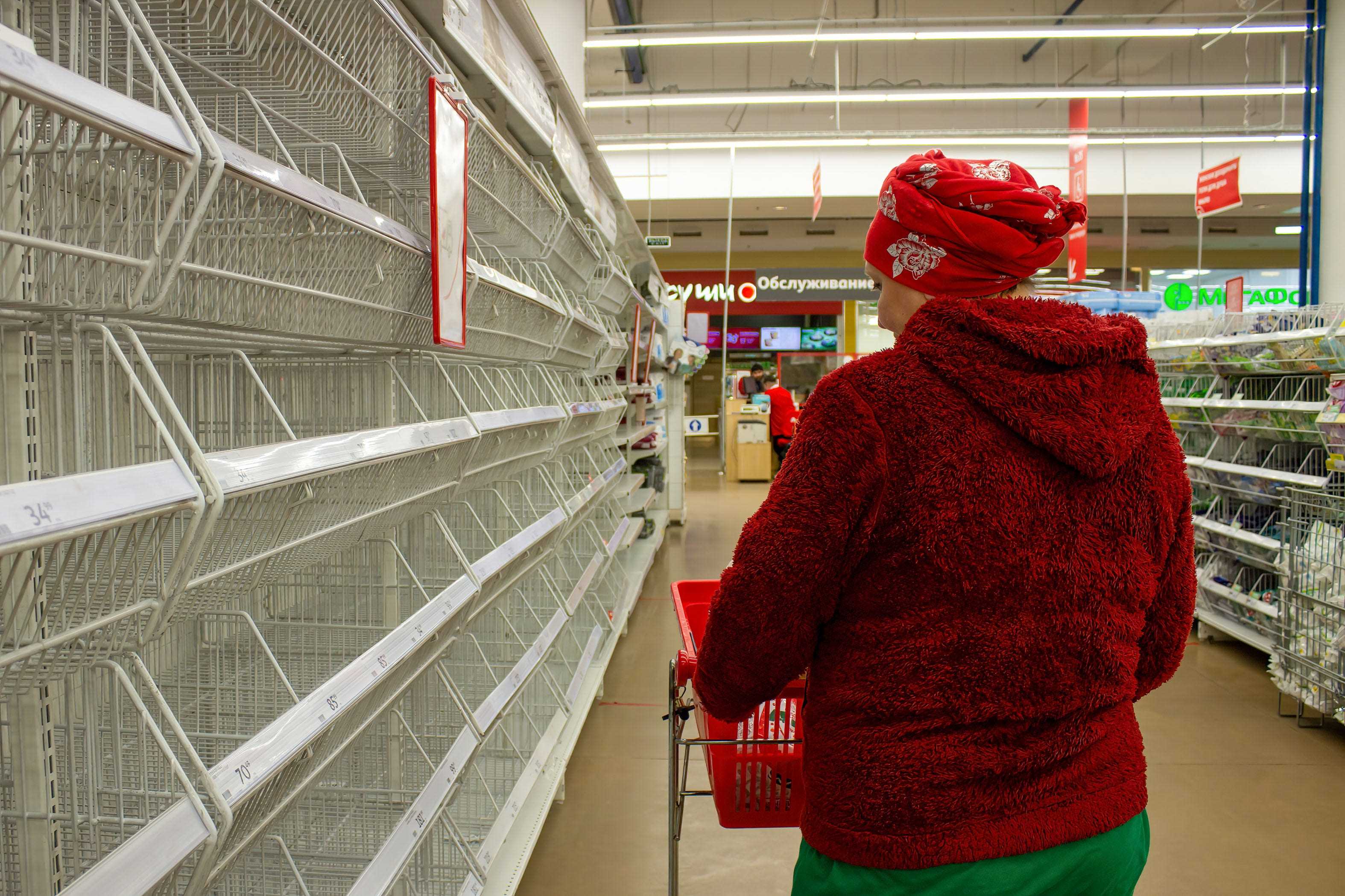 Eine Frau geht am 23. März in Moskau, Russland, an leeren Supermarktregalen vorbei.