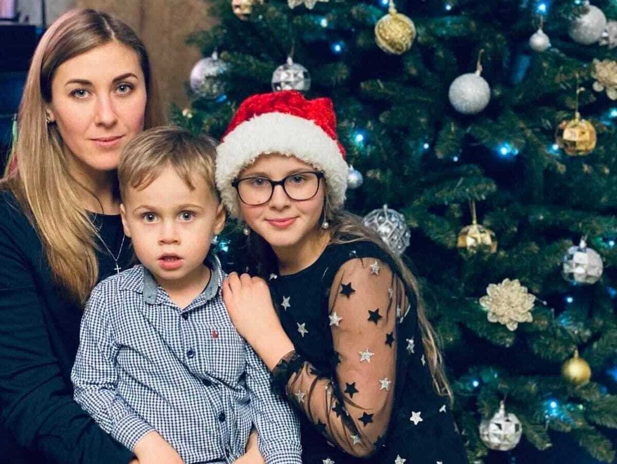 Natalia, Luka und Mariia posieren für ein Weihnachtsfoto