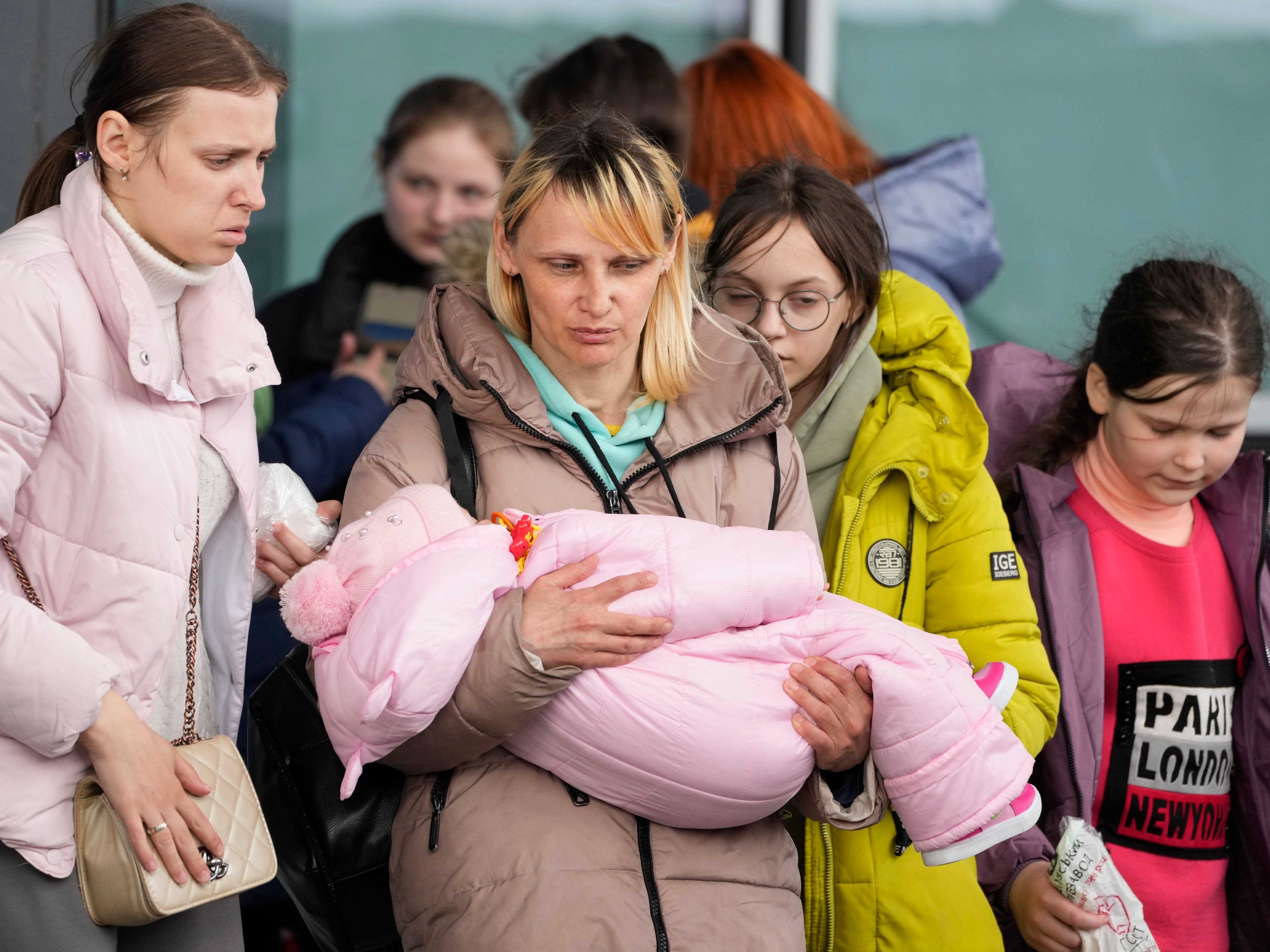 Flüchtlingsfrauen mit Kindern gehen am Donnerstag, 7. April 2022, zum Einstieg in den Transport am Hauptbahnhof in Warschau, Polen.