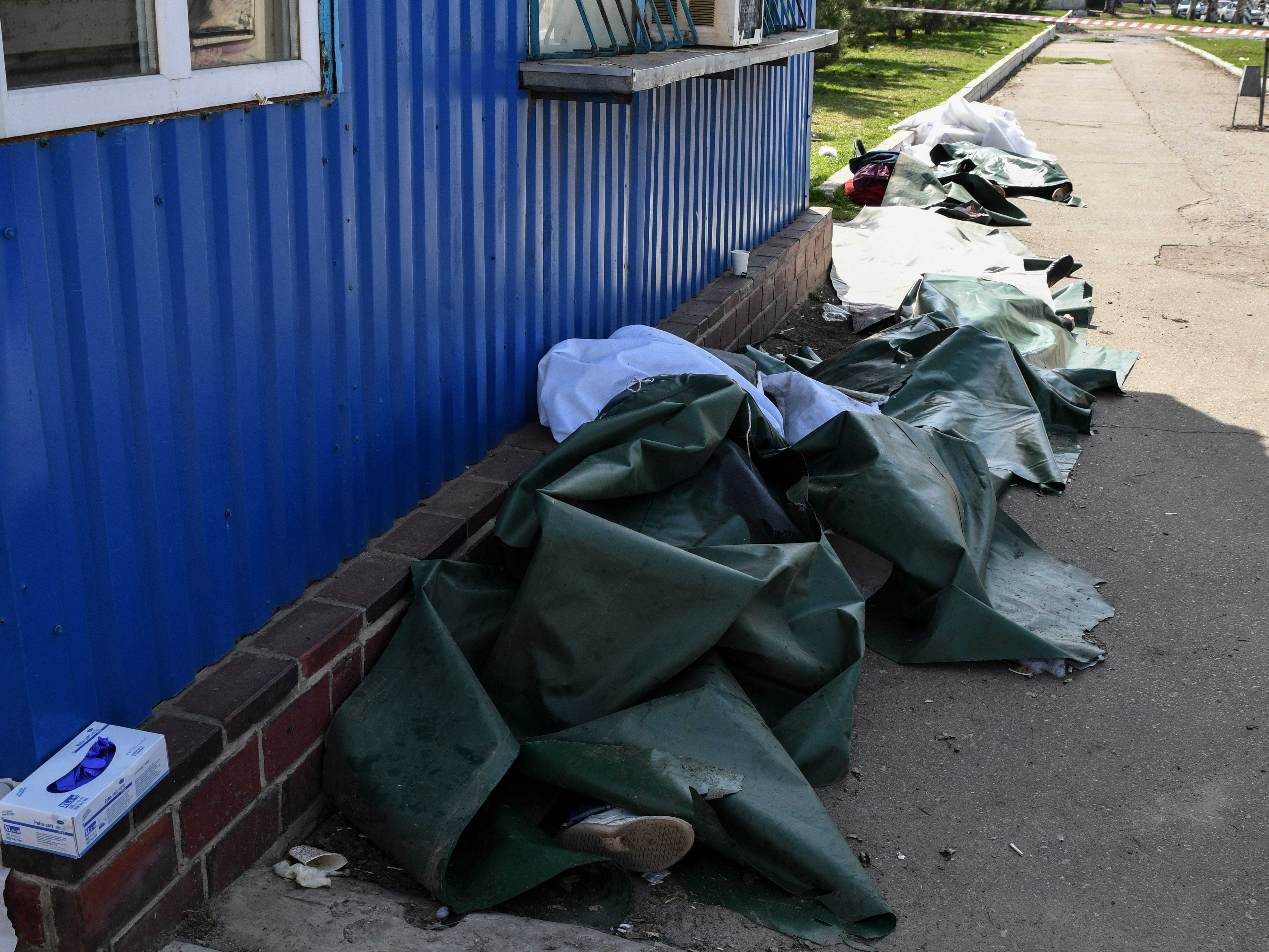Leichen lagen nach russischem Beschuss am Bahnhof in Kramatorsk, Ukraine, Freitag, 8. April 2022, bedeckt.