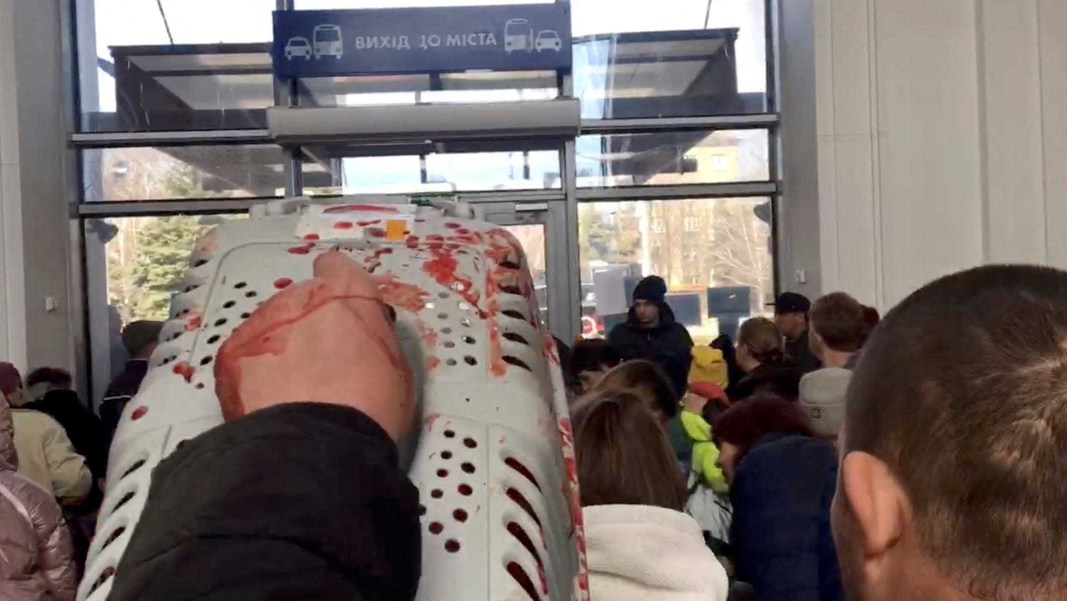 Ein Mann trägt nach einem Streik am Bahnhof von Kramatorsk einen blutbefleckten Tiertransporter