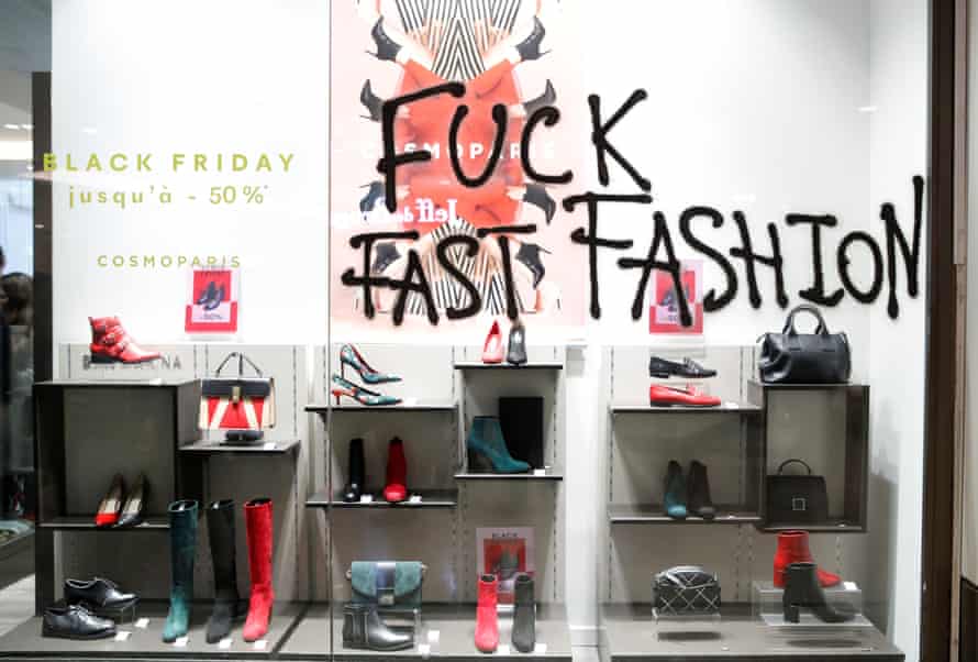 Französische Aktivisten protestieren in Paris gegen den alljährlichen Einkaufsrausch am Schwarzen Freitag.  Auf einem Schaufenster steht der Slogan Fuck Fast Fashion