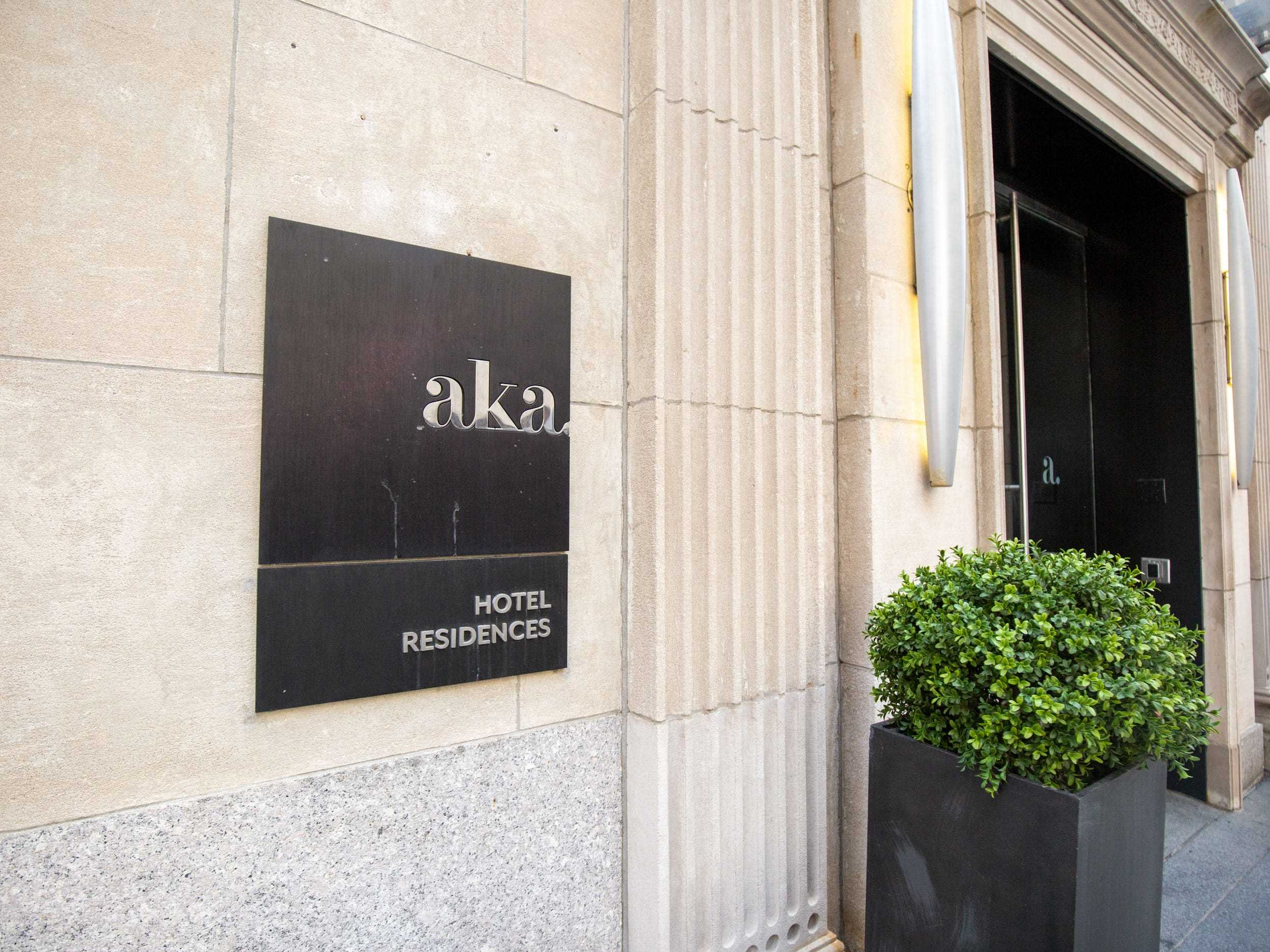 Eine Metallplatte, die auf das AKA Hotel Residences-Gebäude hinweist.