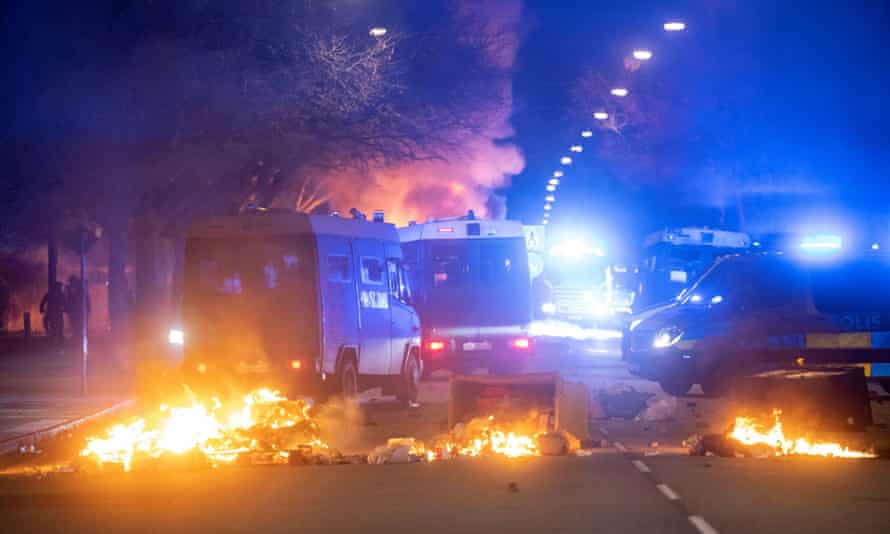 Nach einer von Rasmus Paludan organisierten Demonstration in Malmö werden Bereitschaftskontrollwagen der Polizei in der Nähe brennender Mülleimer gesehen.