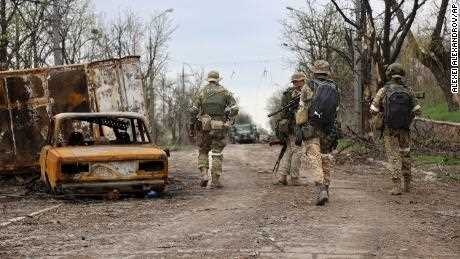 Soldaten der prorussischen Miliz der Volksrepublik Donezk gehen während heftiger Kämpfe in einem von Separatisten kontrollierten Gebiet in Mariupol an beschädigten Fahrzeugen vorbei.