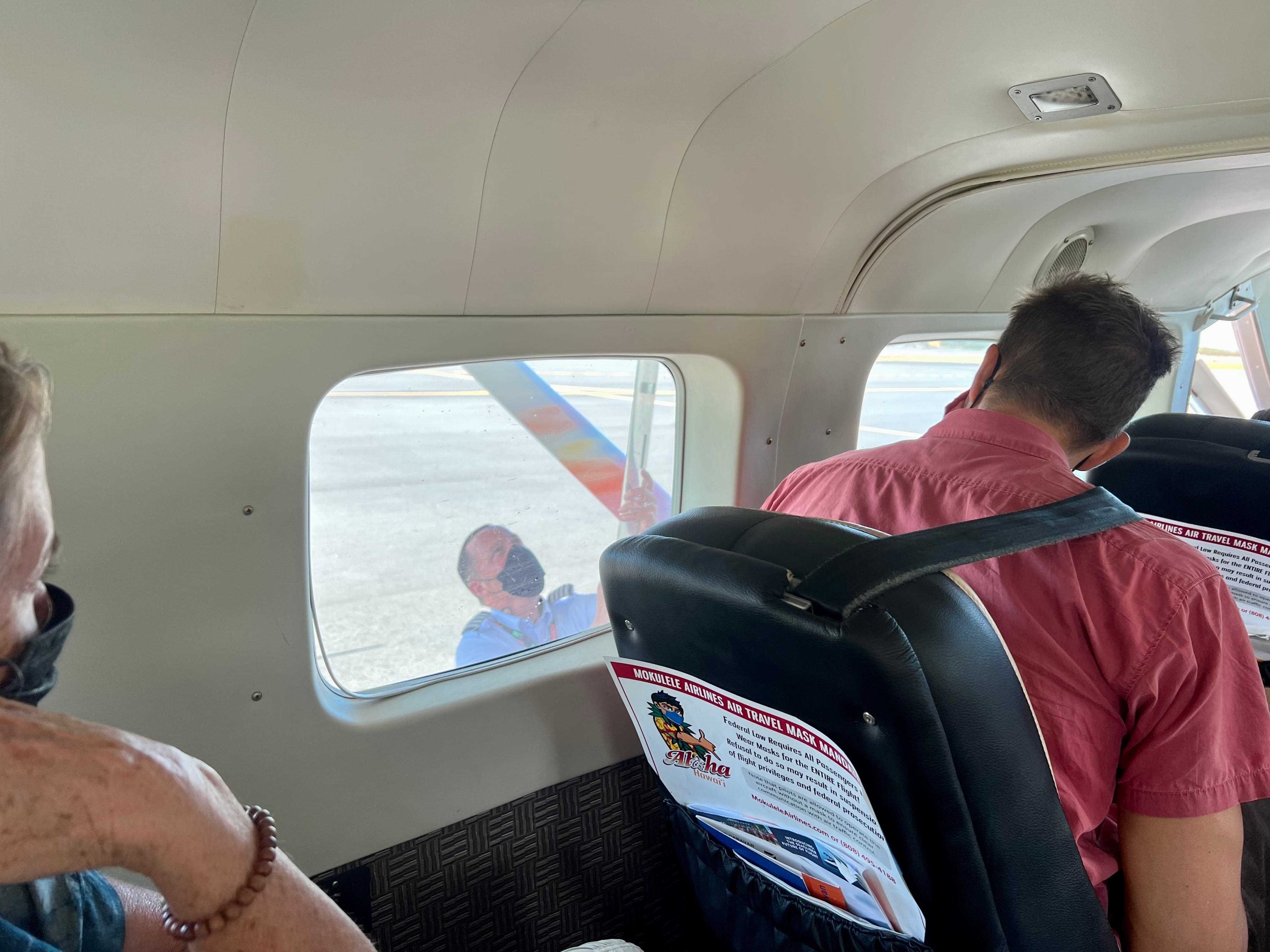 der Blick aus dem Inneren eines Flugzeugs auf den Piloten auf der Tragfläche des Flugzeugs