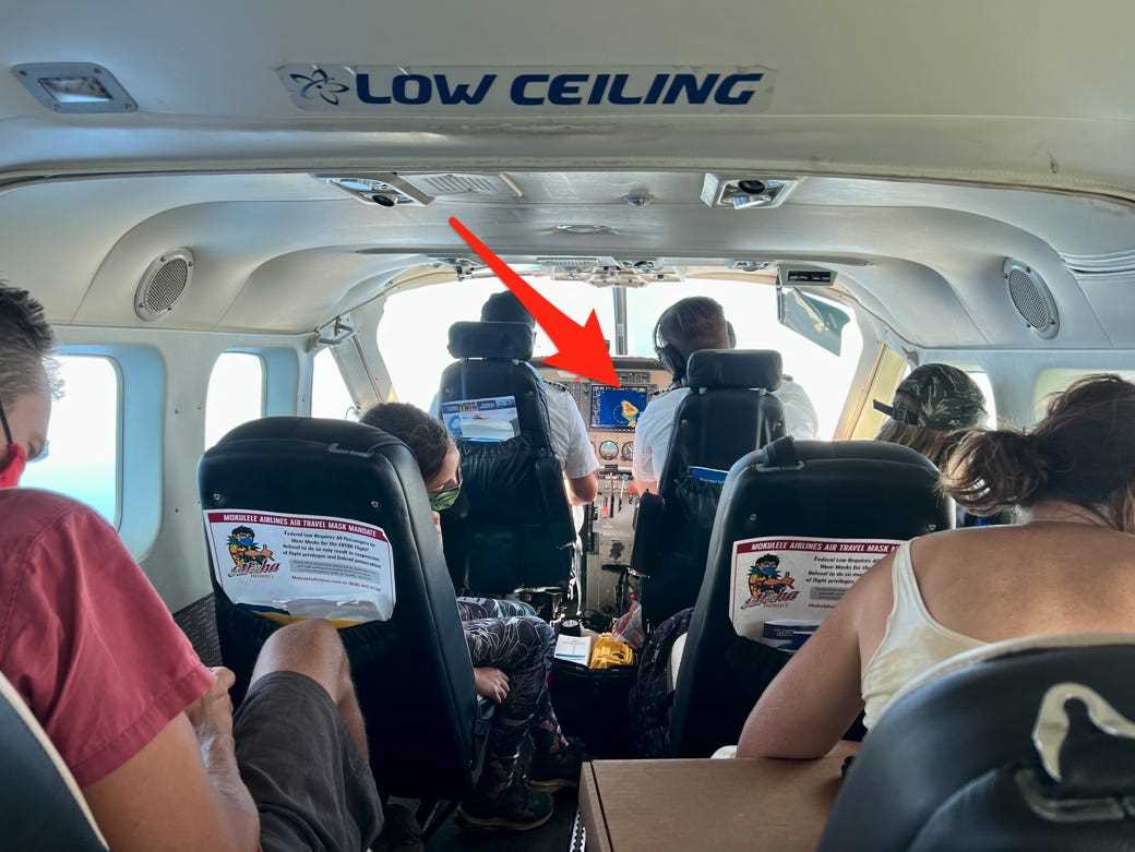 Mein Blick aus dem Flugzeug, in dem die Passagiere dicht beieinander stehen, und die Luftfahrtkarte mit einem darauf weisenden Pfeil