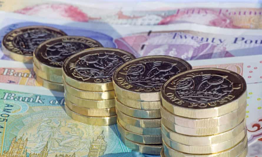 Fünf Stapel neu geprägter Ein-Pfund-Münzen, die in zunehmender Höhe auf britischen Pfund-Noten angeordnet sind.