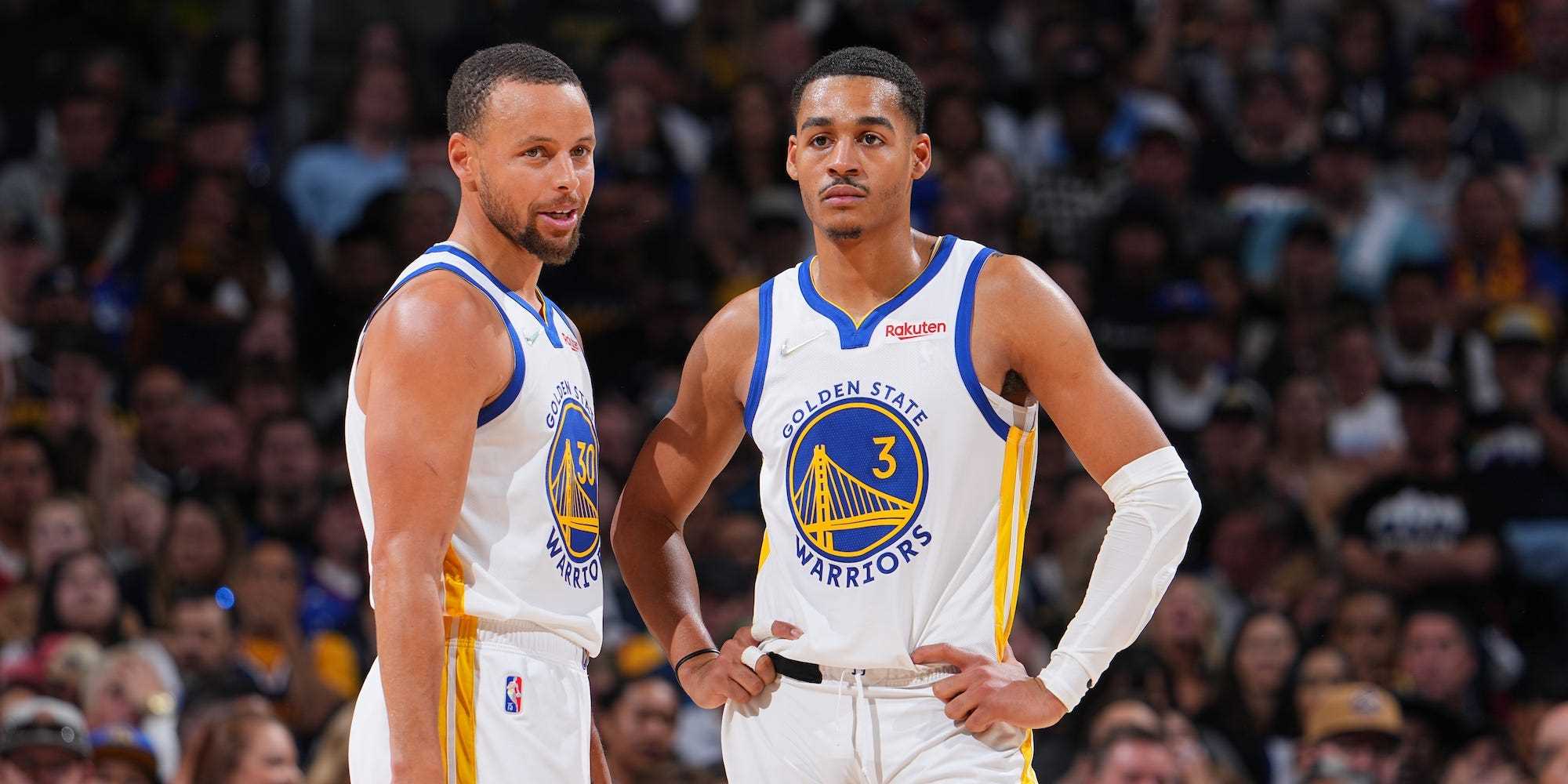 Stephen Curry und Jordan Poole stehen bei einem Playoff-Spiel der Warriors im Jahr 2022 nebeneinander.