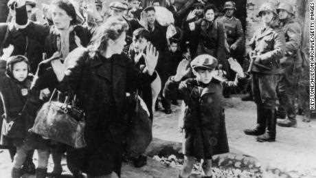Dieses Foto aus einem offiziellen SS-Bericht von 1943 zeigt jüdische Zivilisten, die von Nazi-SS-Truppen mit vorgehaltener Waffe festgehalten wurden, nachdem sie aus einem Bunker vertrieben wurden, in dem sie während des Aufstands im Warschauer Ghetto Zuflucht suchten.