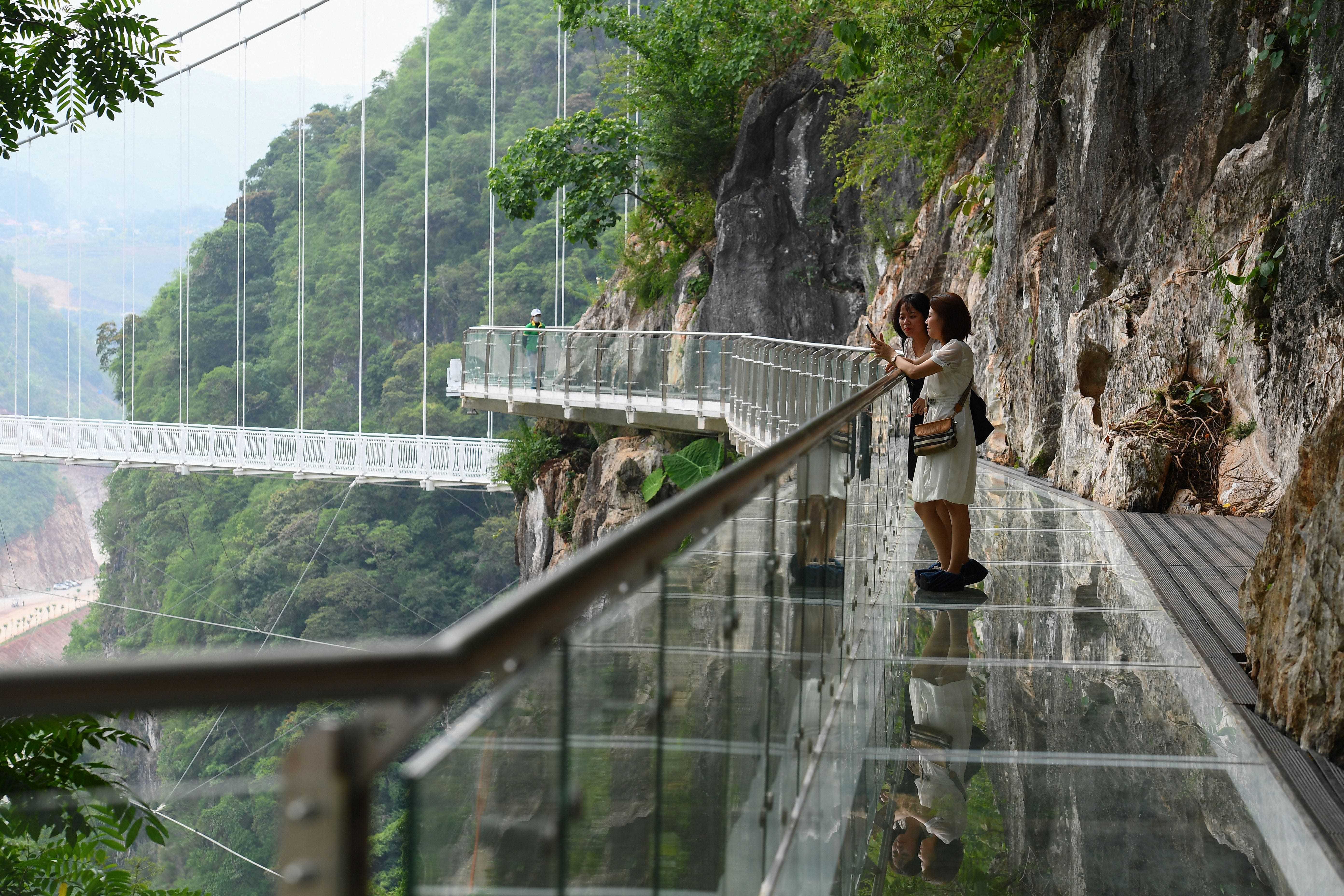 Menschen stehen auf der Glasbrücke Bach Long im Distrikt Moc Chau in der vietnamesischen Provinz Son La