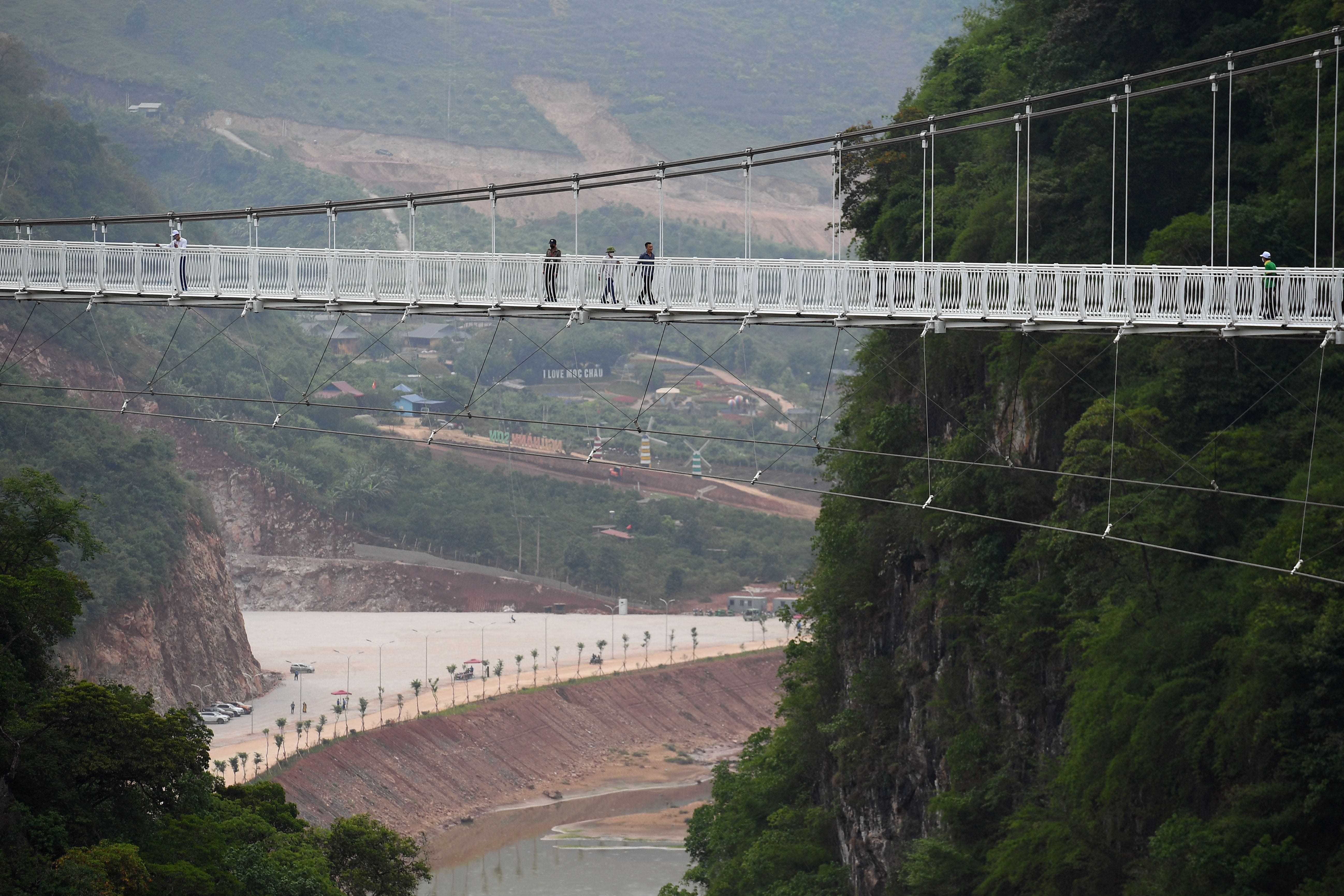 Menschen gehen über die Glasbrücke Bach Long im Distrikt Moc Chau in der vietnamesischen Provinz Son La