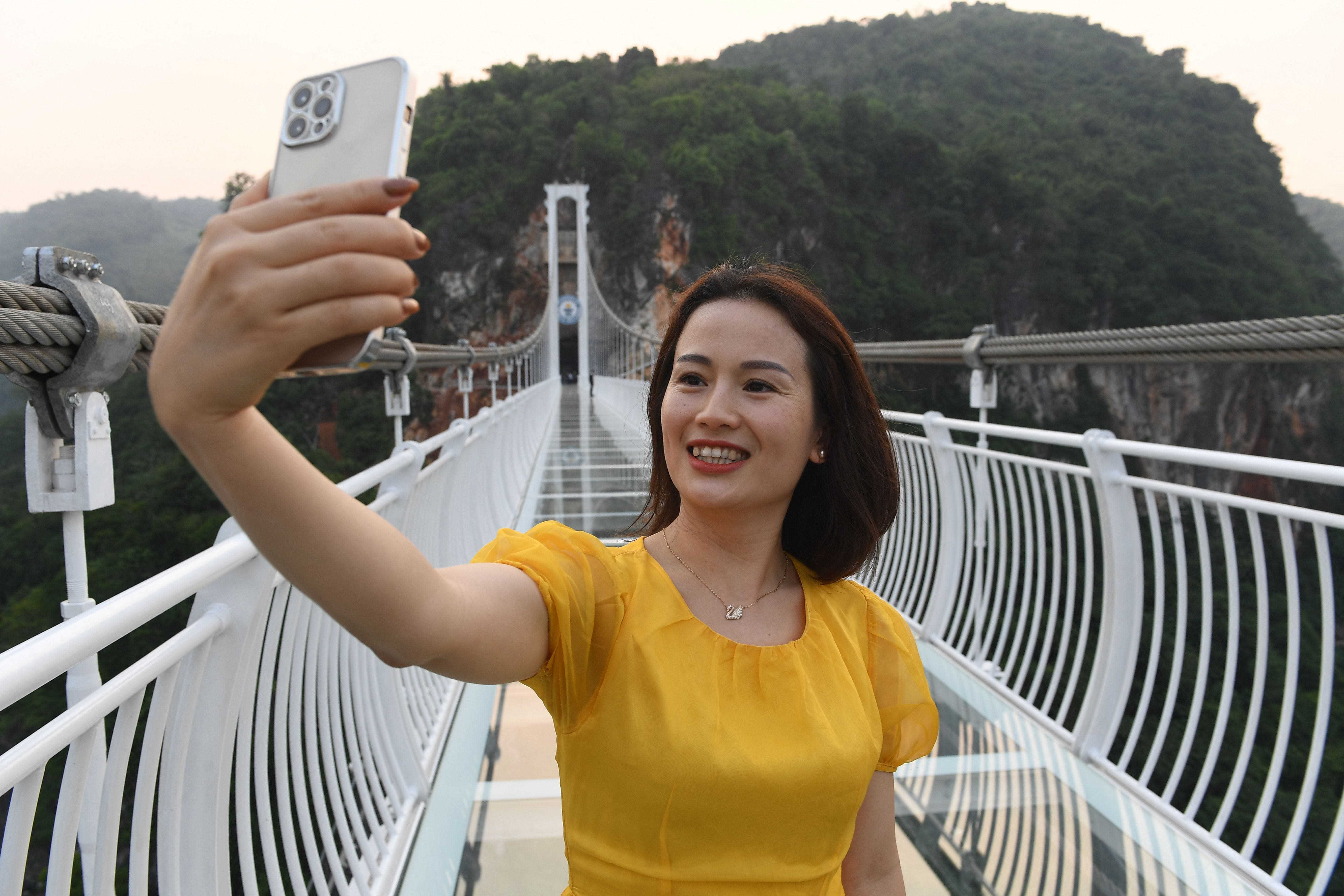 Eine Frau macht ein Selfie auf der Glasbrücke Bach Long im Distrikt Moc Chau in der vietnamesischen Provinz Son La