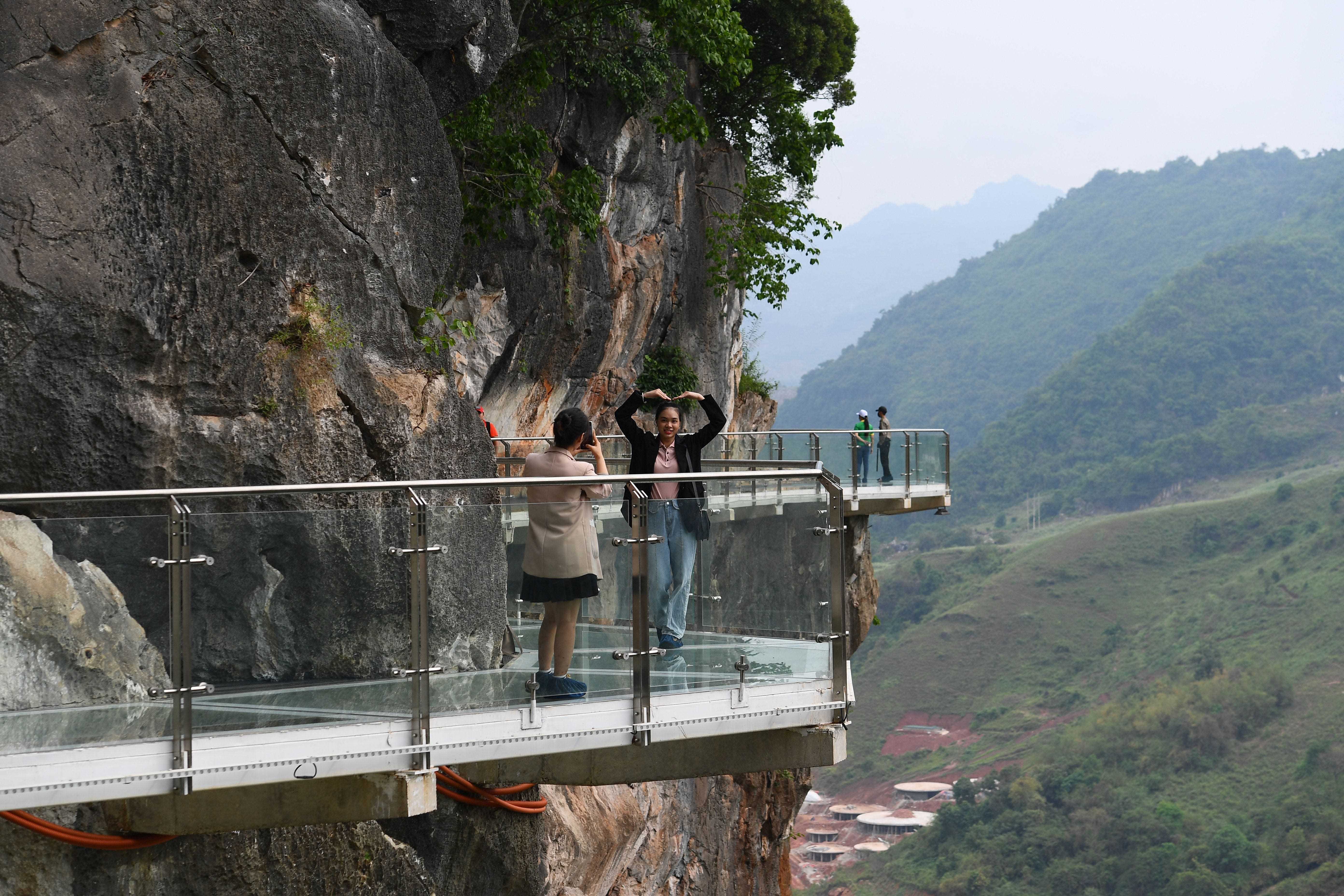 Menschen stehen auf der Glasbrücke Bach Long im Distrikt Moc Chau in der vietnamesischen Provinz Son La