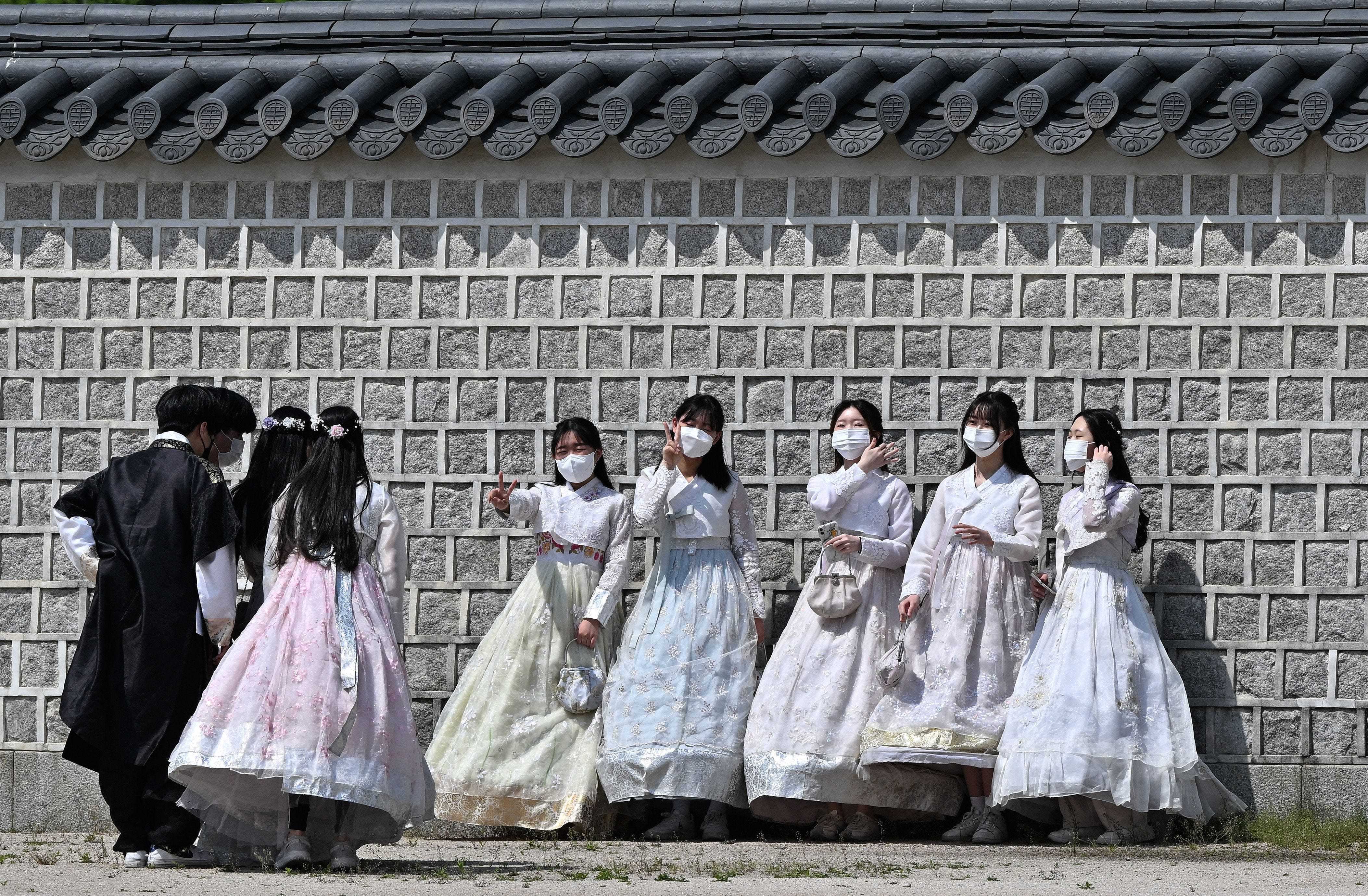 Besucher in traditioneller Hanbok-Kleidung posieren am 2. Mai 2022 im Gyeongbokgung-Palast in Seoul für Fotos, nachdem Südkorea sein Außenmasken-Mandat als Reaktion auf einen stetigen Rückgang der Covid-19-Fälle aufgehoben hatte.