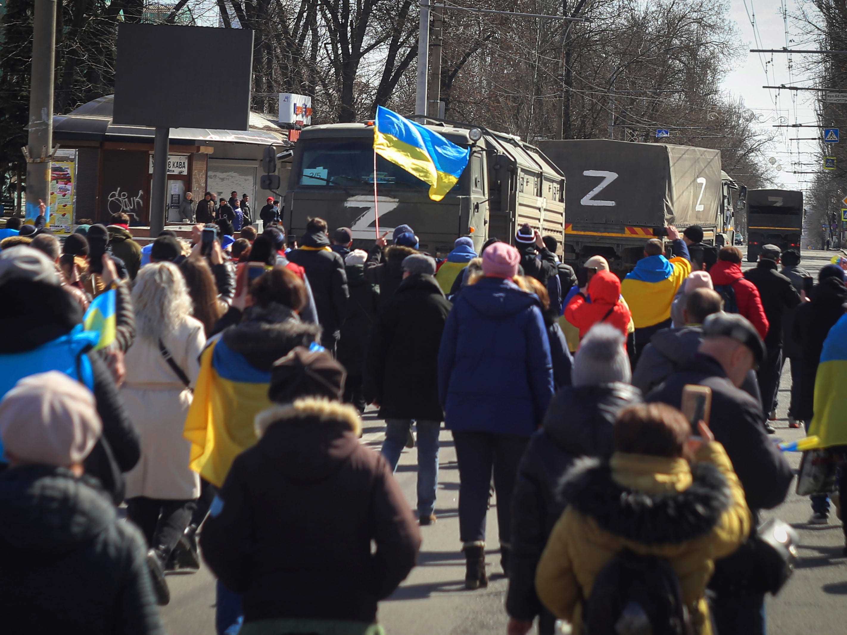 Ukrainische Demonstranten gehen auf Lastwagen der russischen Armee zu.