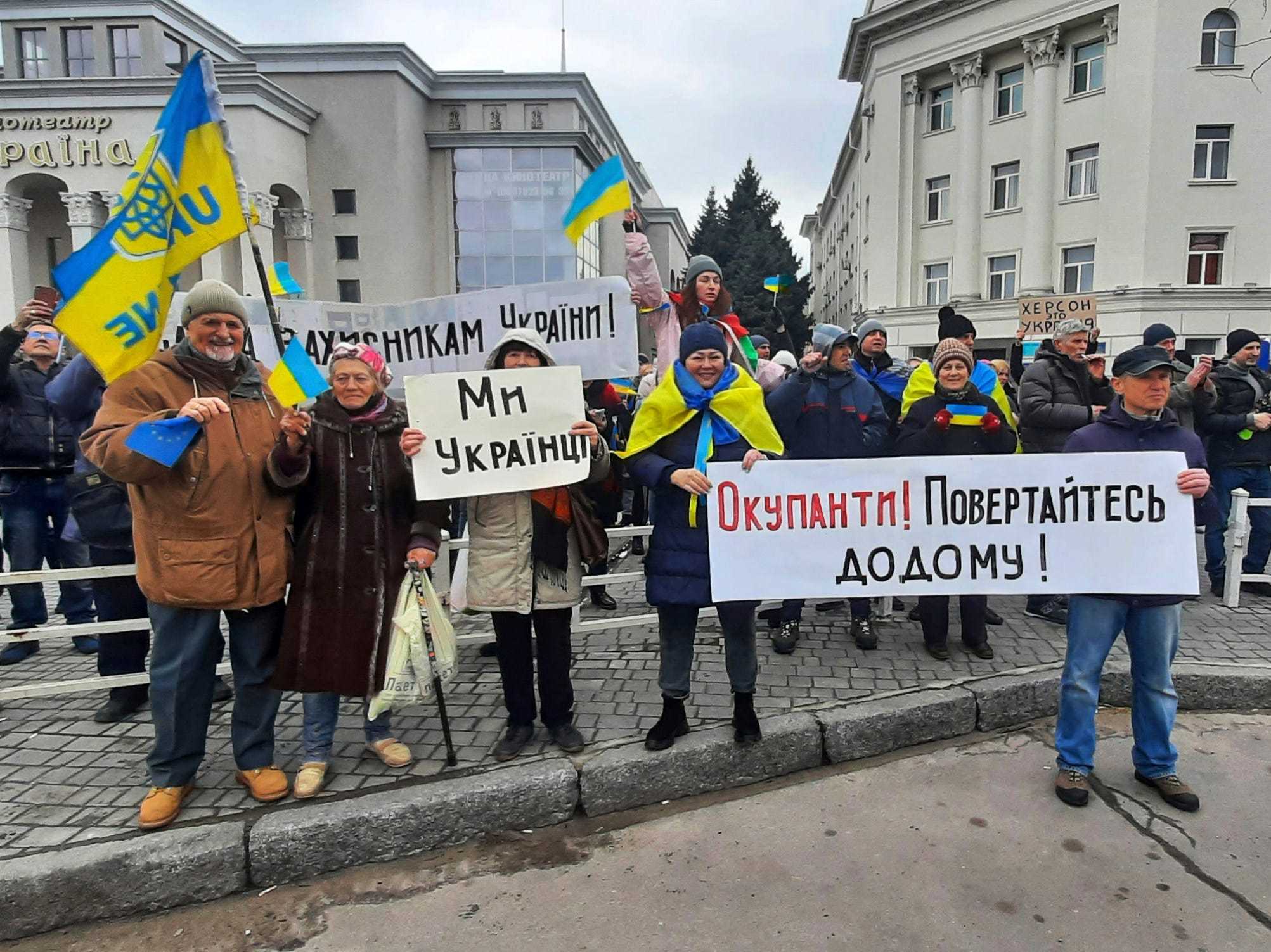 Eine Menge Ukrainer stehen mit Protestschildern.
