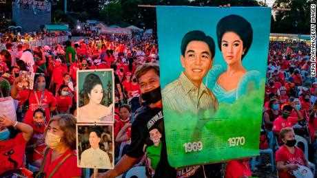 Ein Marcos-Anhänger hält Bilder des verstorbenen Diktators Ferdinand und seiner Frau Imelda, als Ferdinand "Bongbong"  Marcos Jr. veranstaltet im Februar dieses Jahres eine Wahlkampfveranstaltung. 