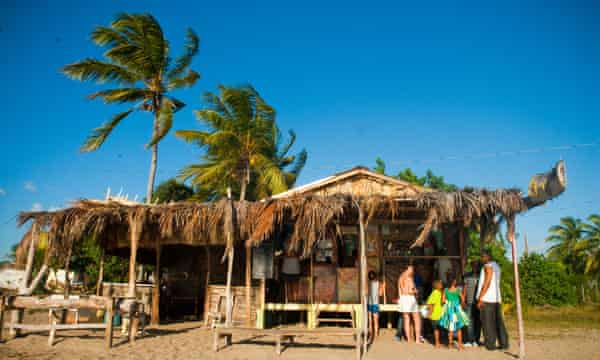 Einheimische und Reisende in einer Bar und einem Restaurant am Treasure Beach in St. Elizabeth, Jamaika.