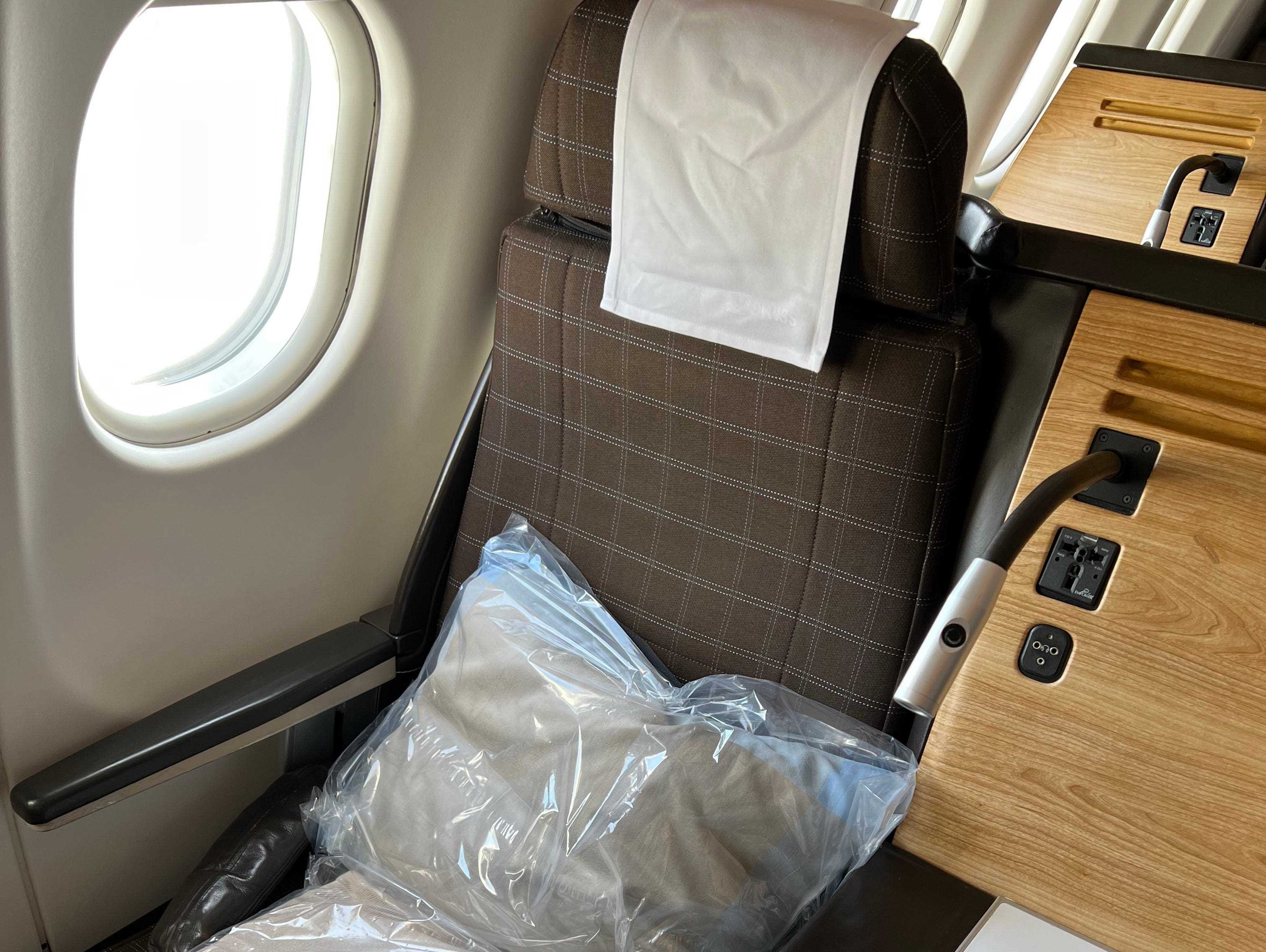 Ein SwissAir-Business-Class-Sitz mit Decke und Kissen darauf