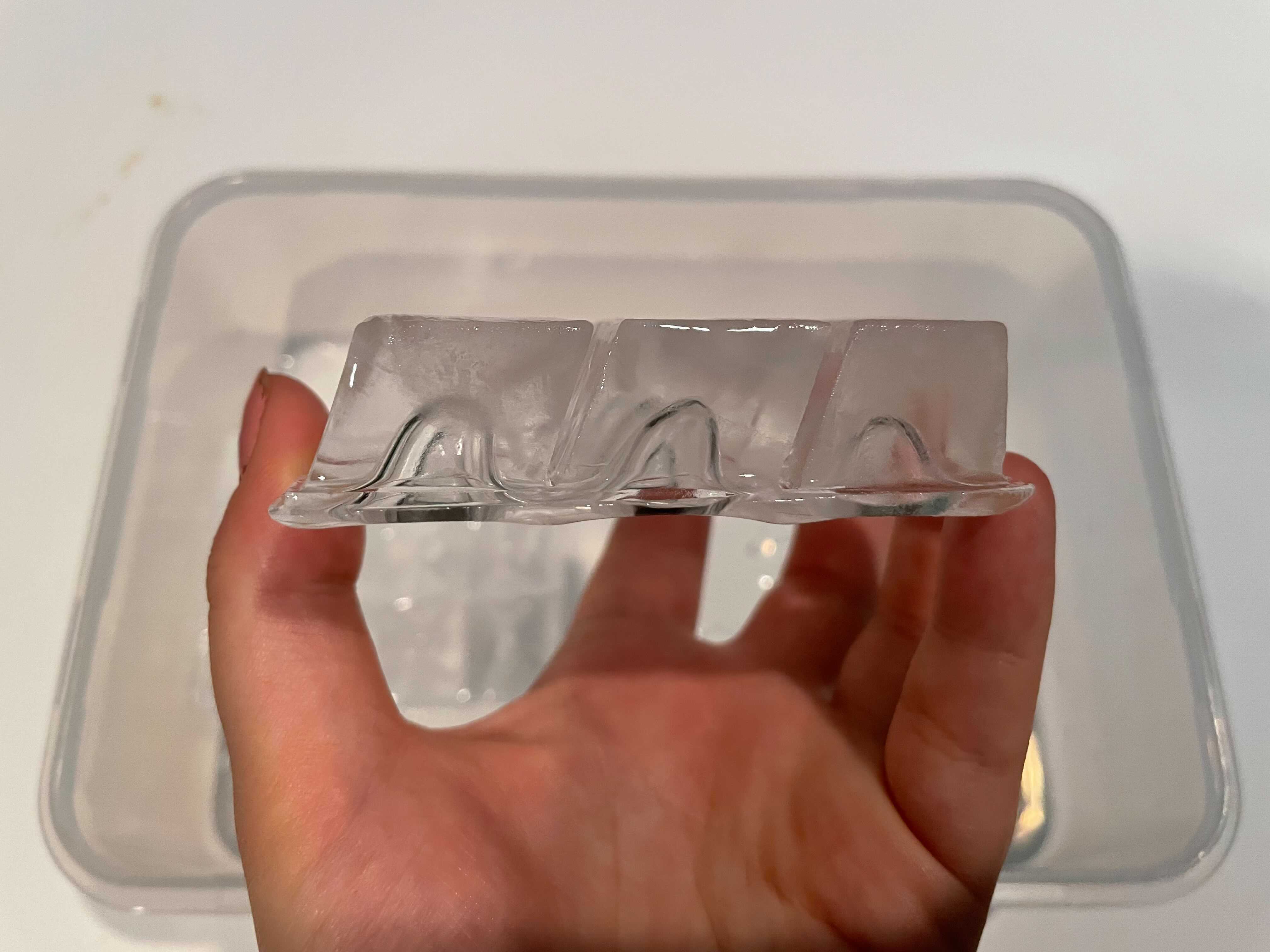 Eine Hand, die drei halbklare Eiswürfel hält, die aus dem Luma Comfort Clear Ice Maker im Rahmen des Tests für den besten Eisbereiter im Jahr 2022 zusammengefroren wurden