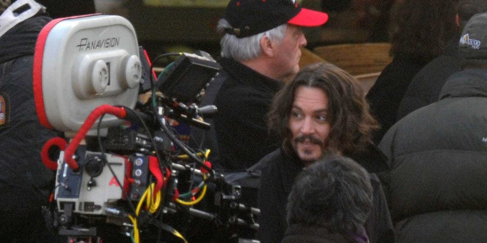 Johnny Depp in einer Menschenmenge mit einer Filmkamera im Vordergrund am Set von „The Tourist“ im Jahr 2010.