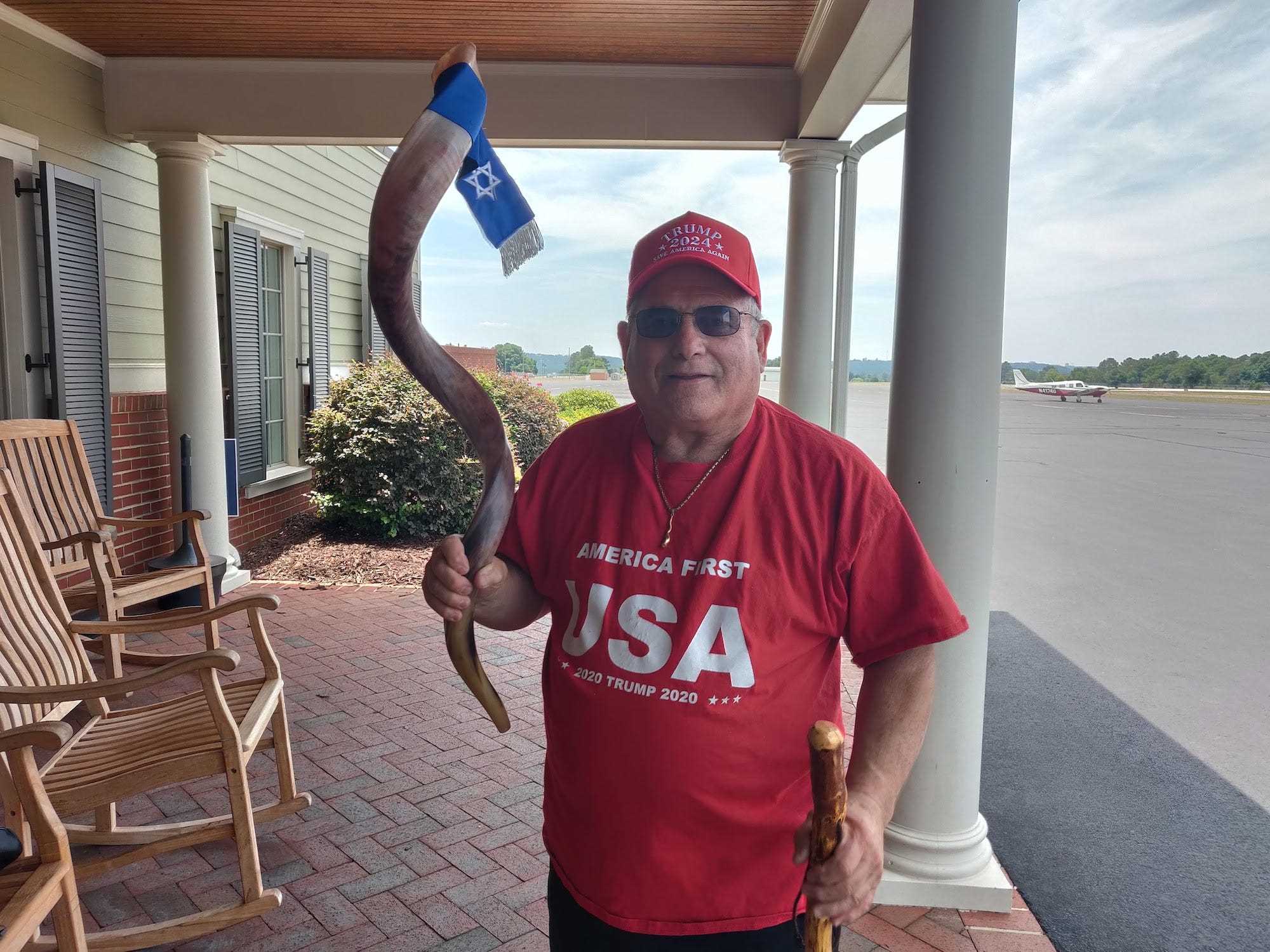 Der Georgier Robert Weinger, der das T-Shirt Trump 2020 und die Ballkappe Trump 2024 trägt, hält ein zeremonielles Schofarhorn in der rechten Hand, während er am 20. Mai bei einer David Perdue for Governor Rally in Augusta, Georgia, für ein Foto posiert.