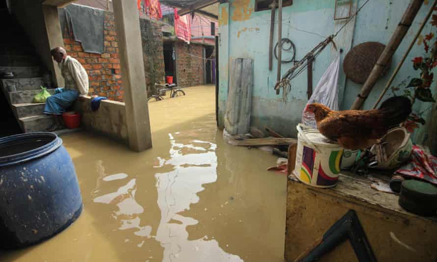 Ein Mann in einem überschwemmten Wohngebiet von Sylhet