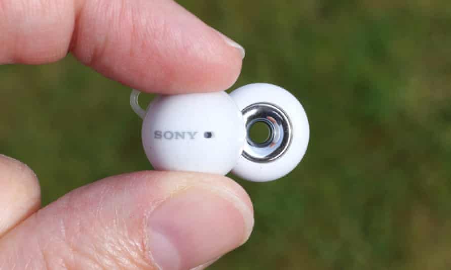 Der Sony LinkBud, der zwischen zwei Fingern gehalten wird, zeigt das Loch in der Mitte des Lautsprechers.