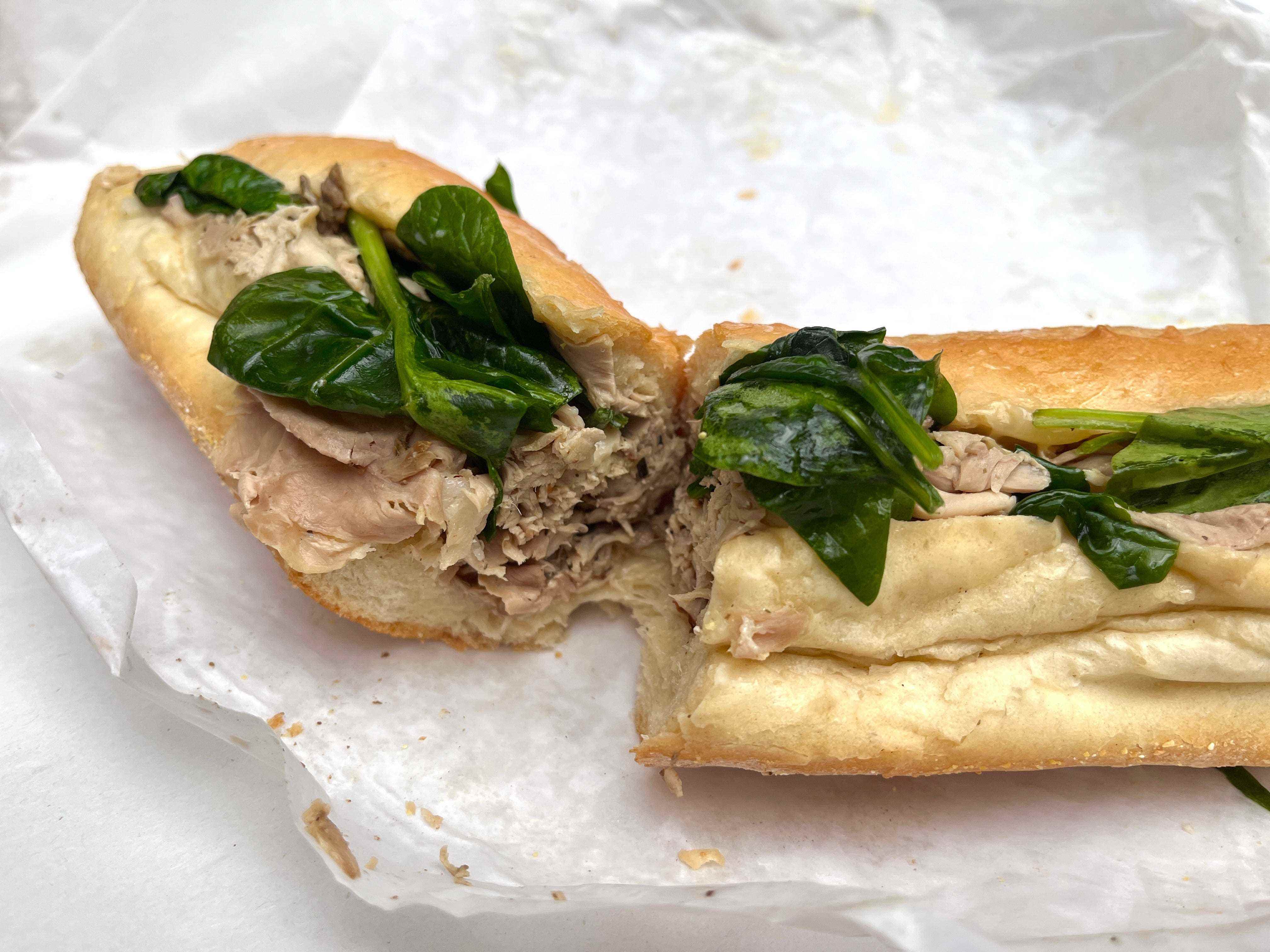 Ein Schweinebraten-Sandwich mit Spinat und Käse auf einem Wrapper
