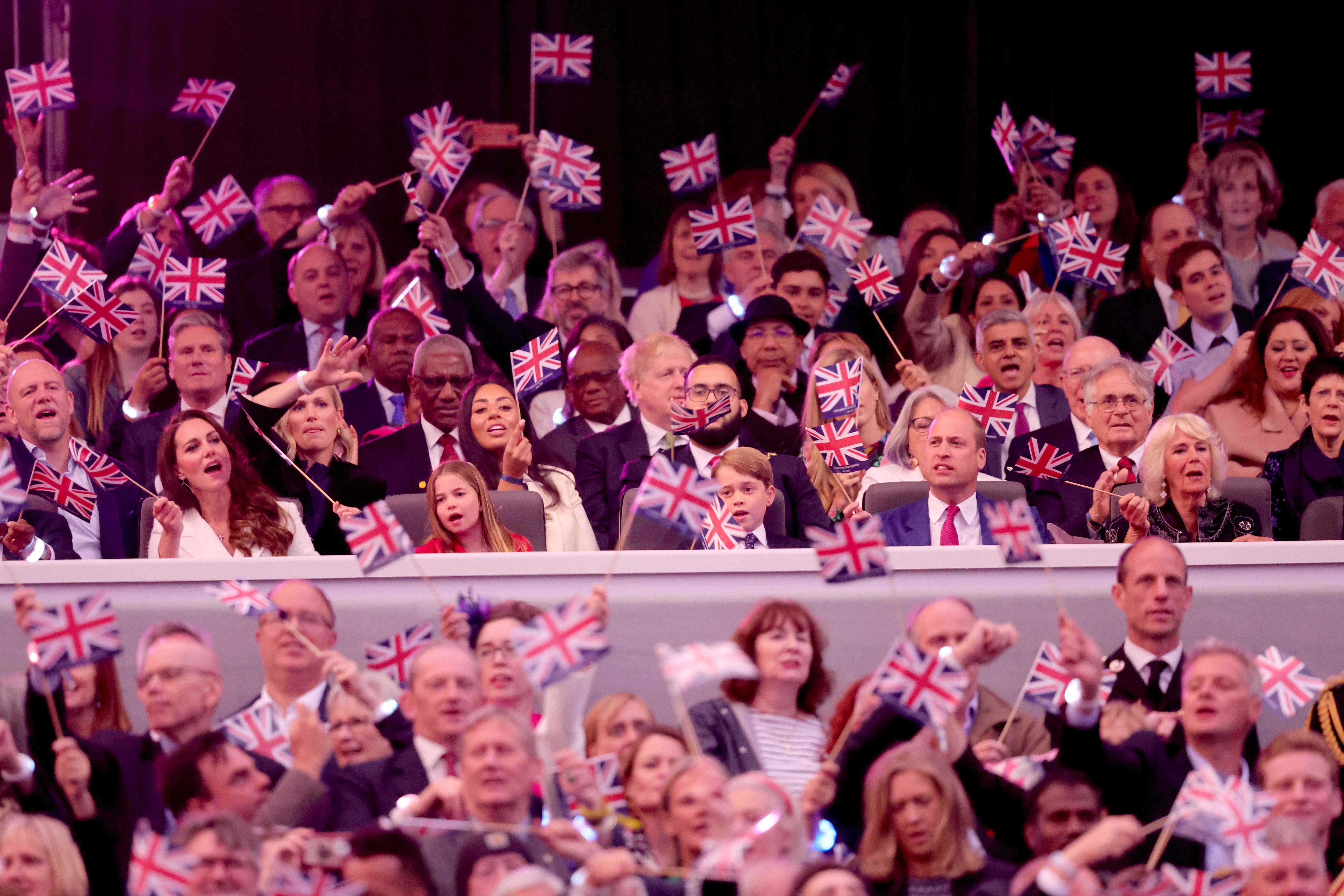 Herzogin von Cambridge Kate Middleton, Prinzessin Charlotte, Prinz George, Prinz William, Herzog von Cambridge schwenken Union Jack-Flaggen, während „Sweet Caroline“ während der Platinum Party vor dem Buckingham Palace am 4. Juni 2022 in London, England, spielt.