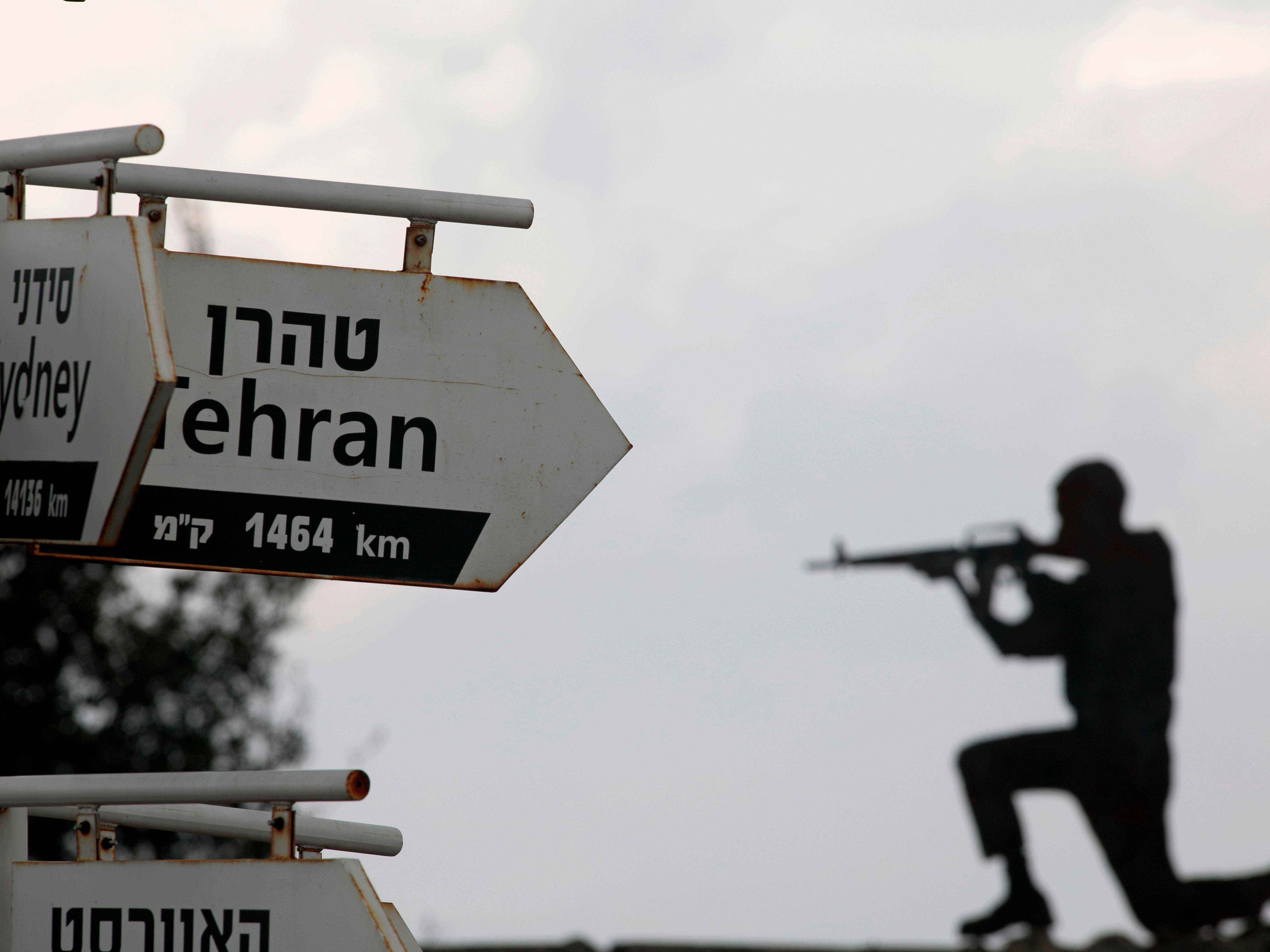 Ein Ausschnitt eines israelischen Soldaten ist am 28. November 2020 auf einem Armeeposten in Mount Bental auf den von Israel annektierten Golanhöhen hinter Schildern zu sehen, die auf die Entfernungen zu verschiedenen Städten hinweisen.