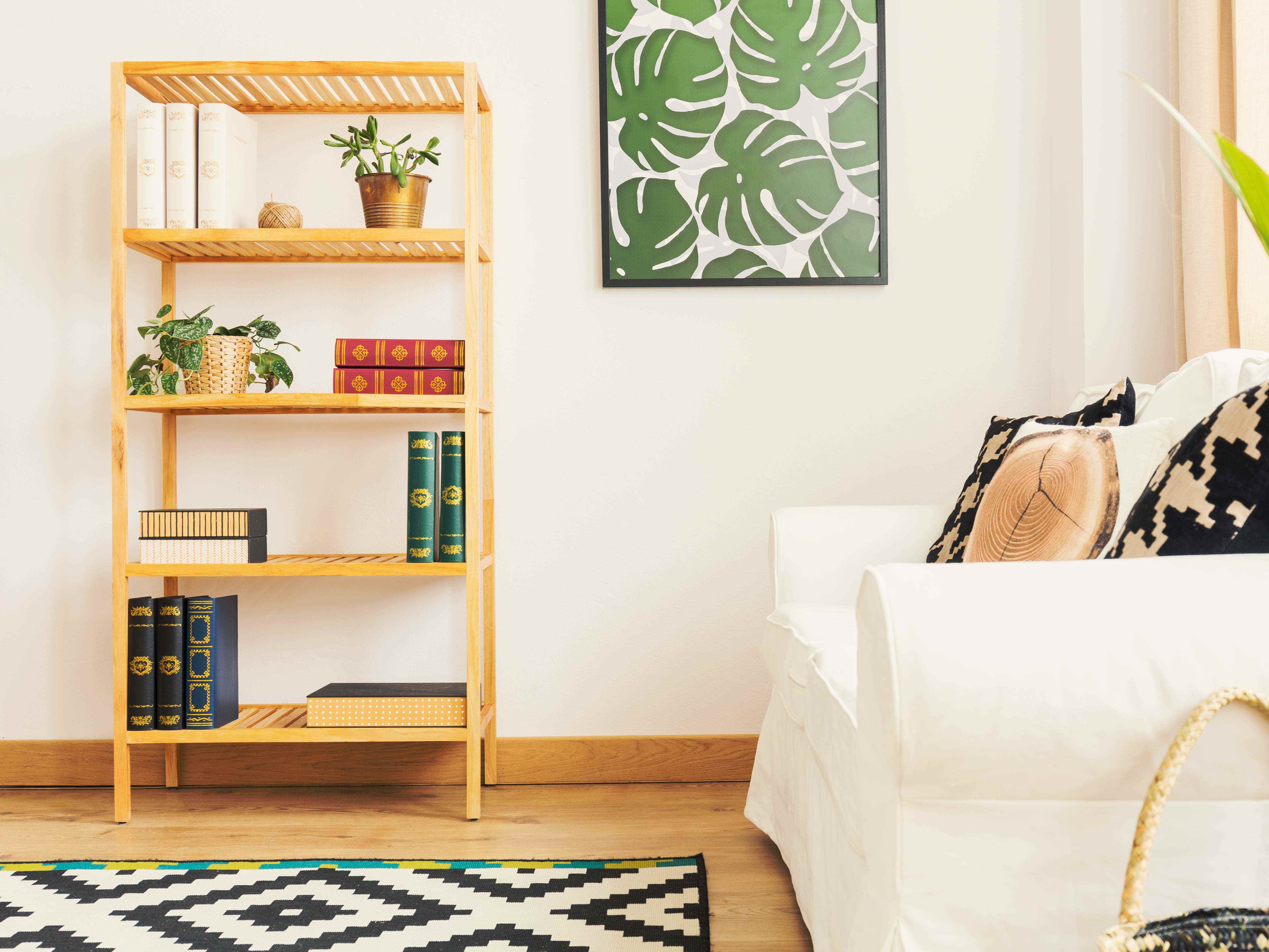 Wohnzimmer mit Sofa, Kunst und sauberem Bücherregal aus Holz