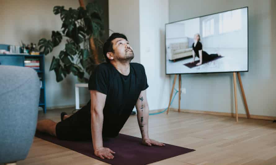 Ein Japaner, der in seinem Wohnzimmer Online-Yogaunterricht nimmt.
