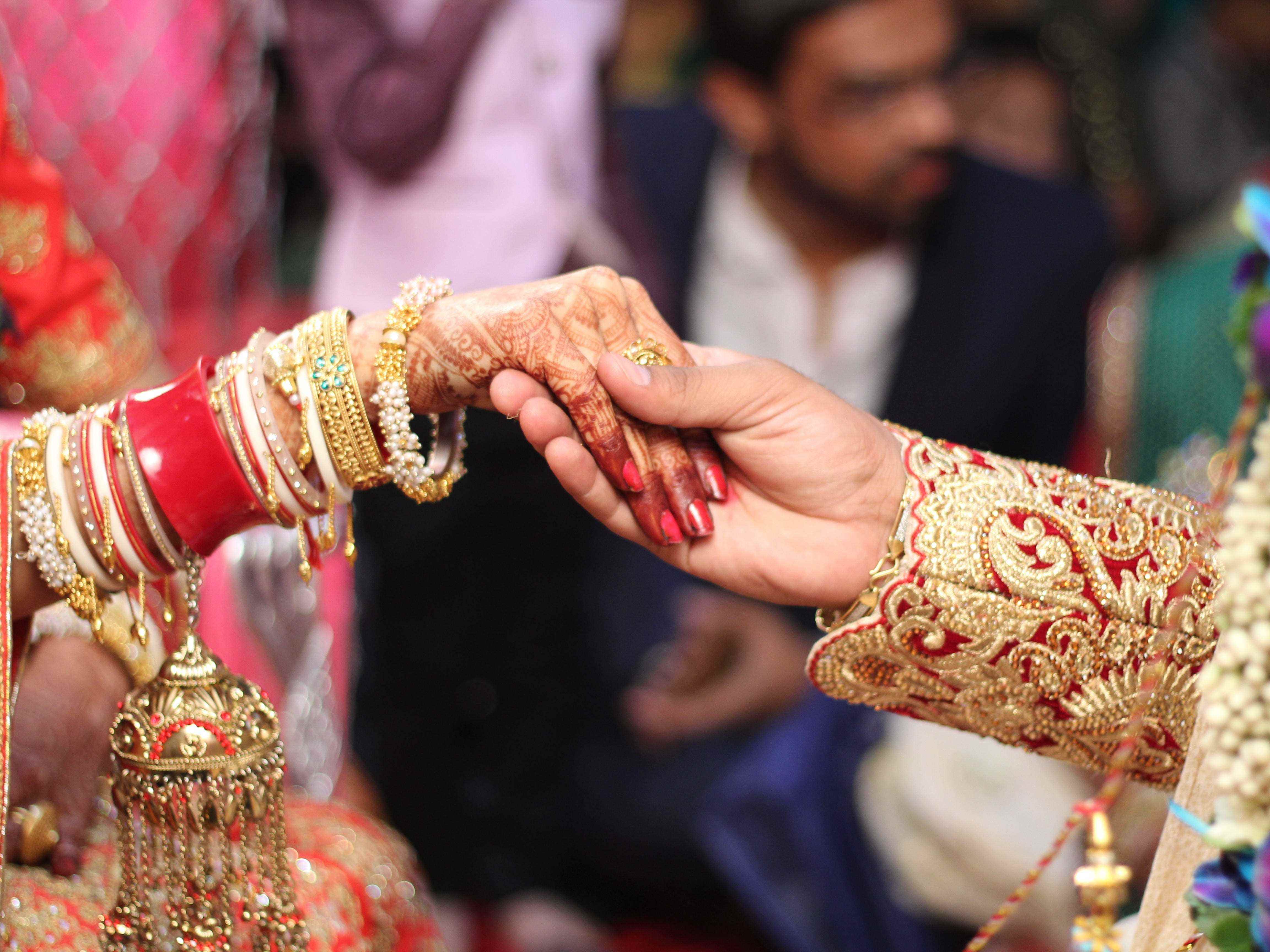 Jungvermähltenpaar Händchen haltend bei Hochzeitszeremonie in Indien