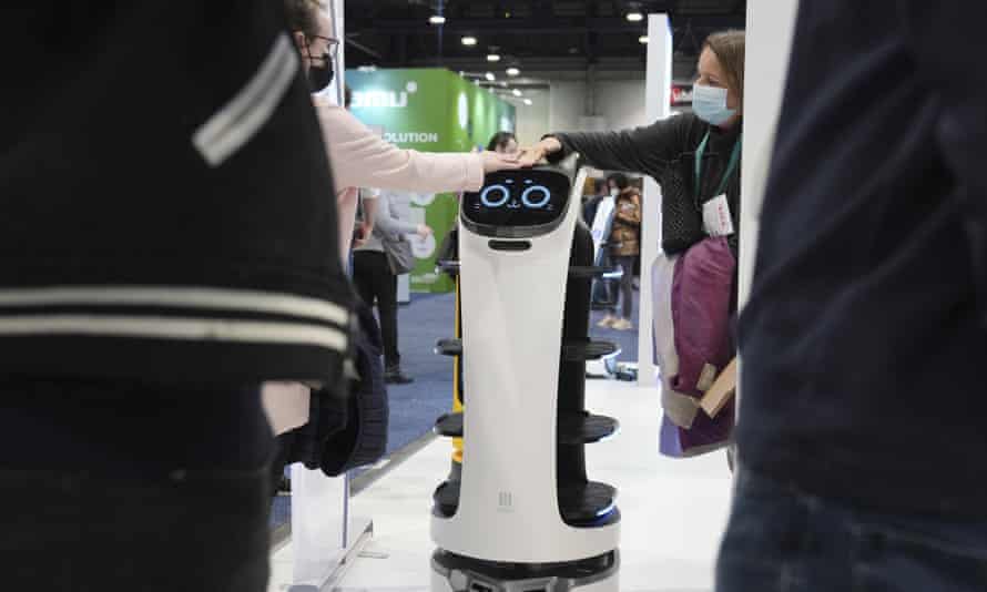 Menschen interagieren mit dem BellaBot-Lieferroboter am Pudu-Stand auf der CES-Tech-Show in Las Vegas.
