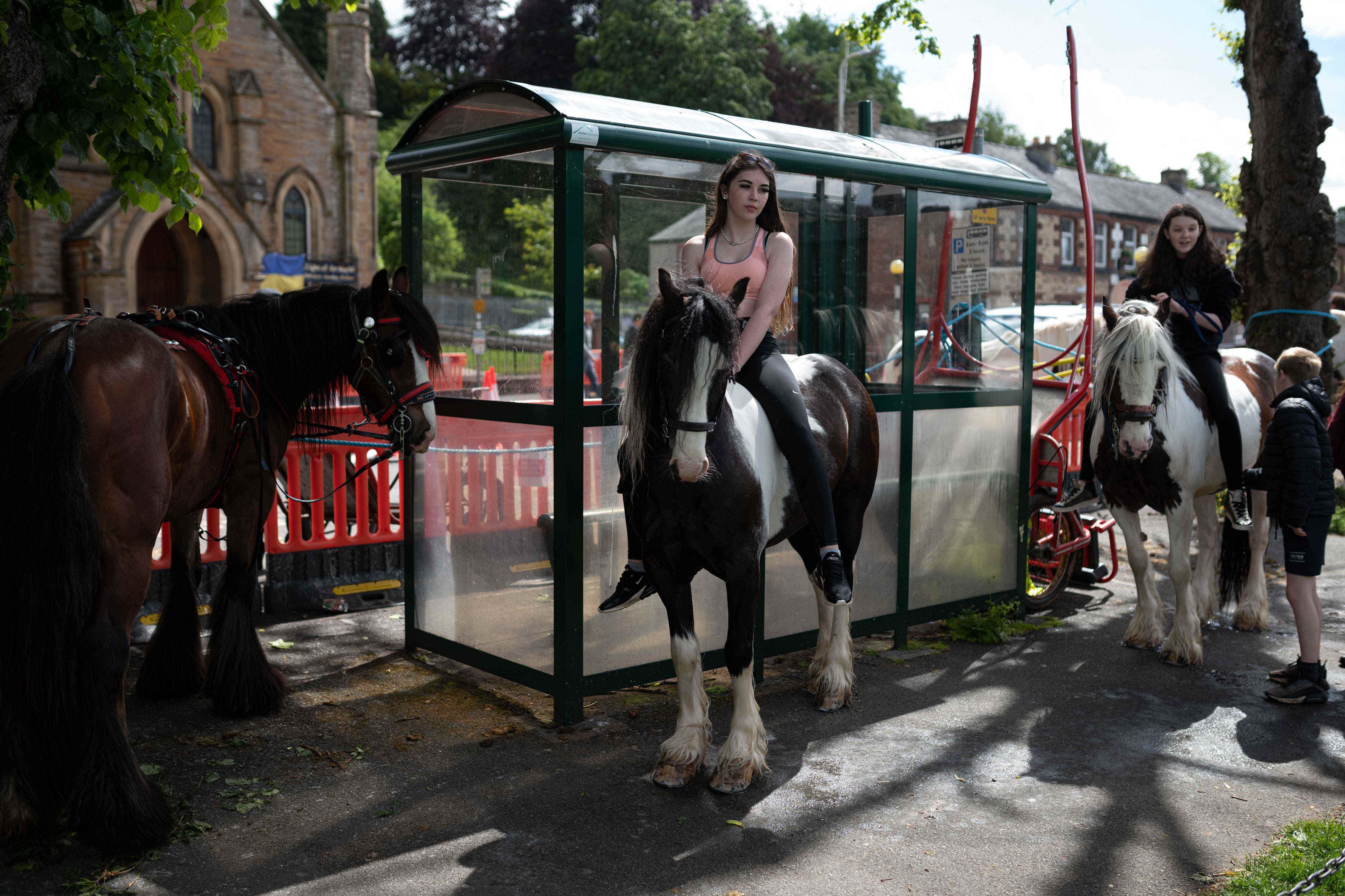 Mädchen warten am ersten Tag der jährlichen Appleby Horse Fair in der Stadt Appleby-in-Westmorland im Nordwesten Englands am 9. Juni 2022 auf ihren Pferden.