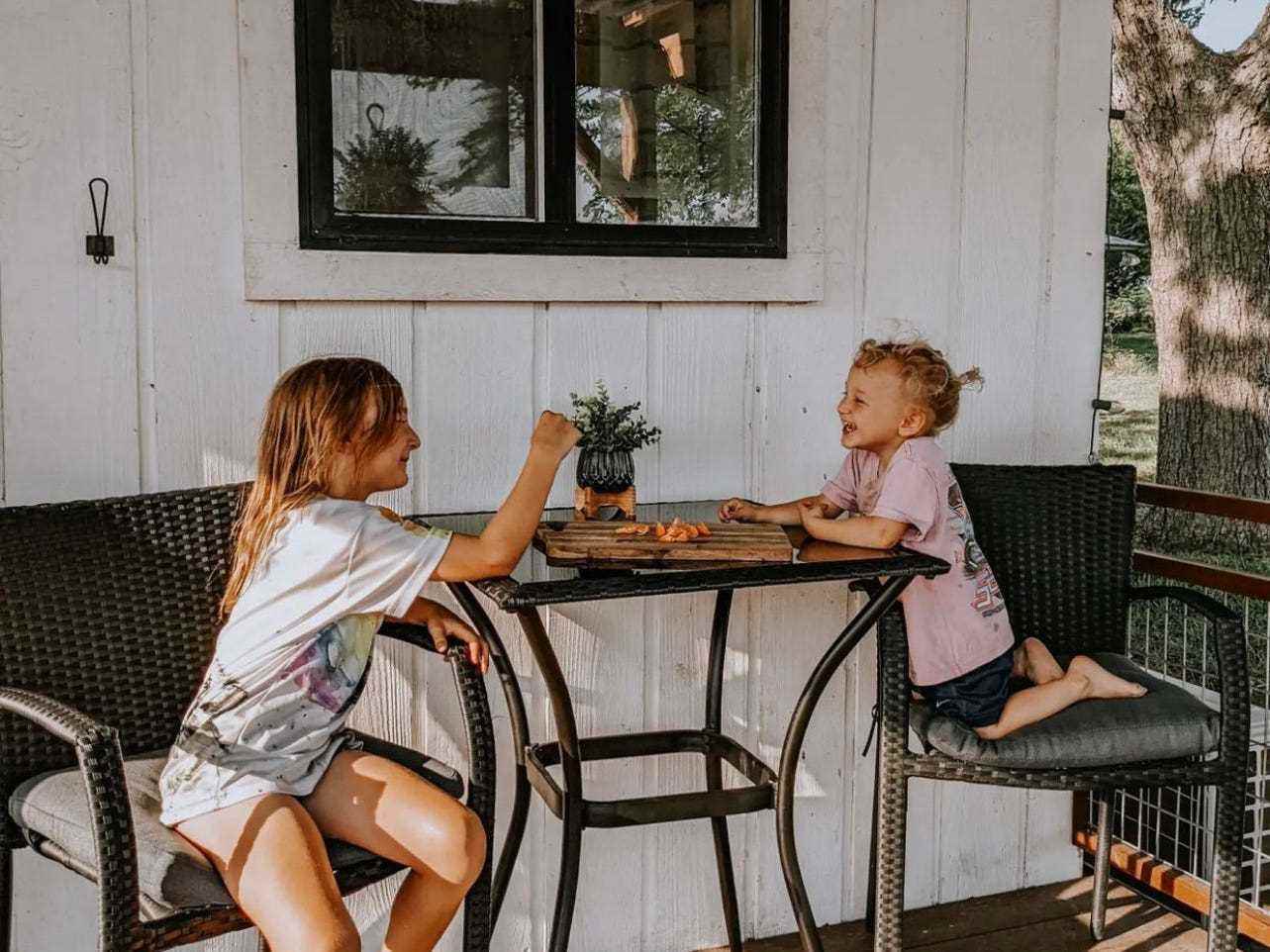 Katys zwei Töchter, Carolina und Harper, sitzen auf der Veranda.