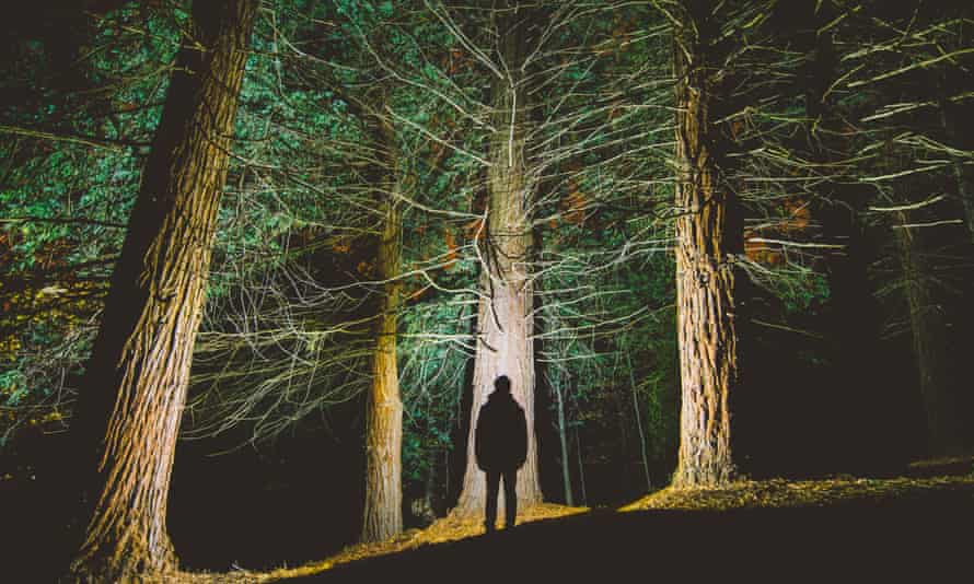 Die Silhouette des Mannes in einem dunklen Wald