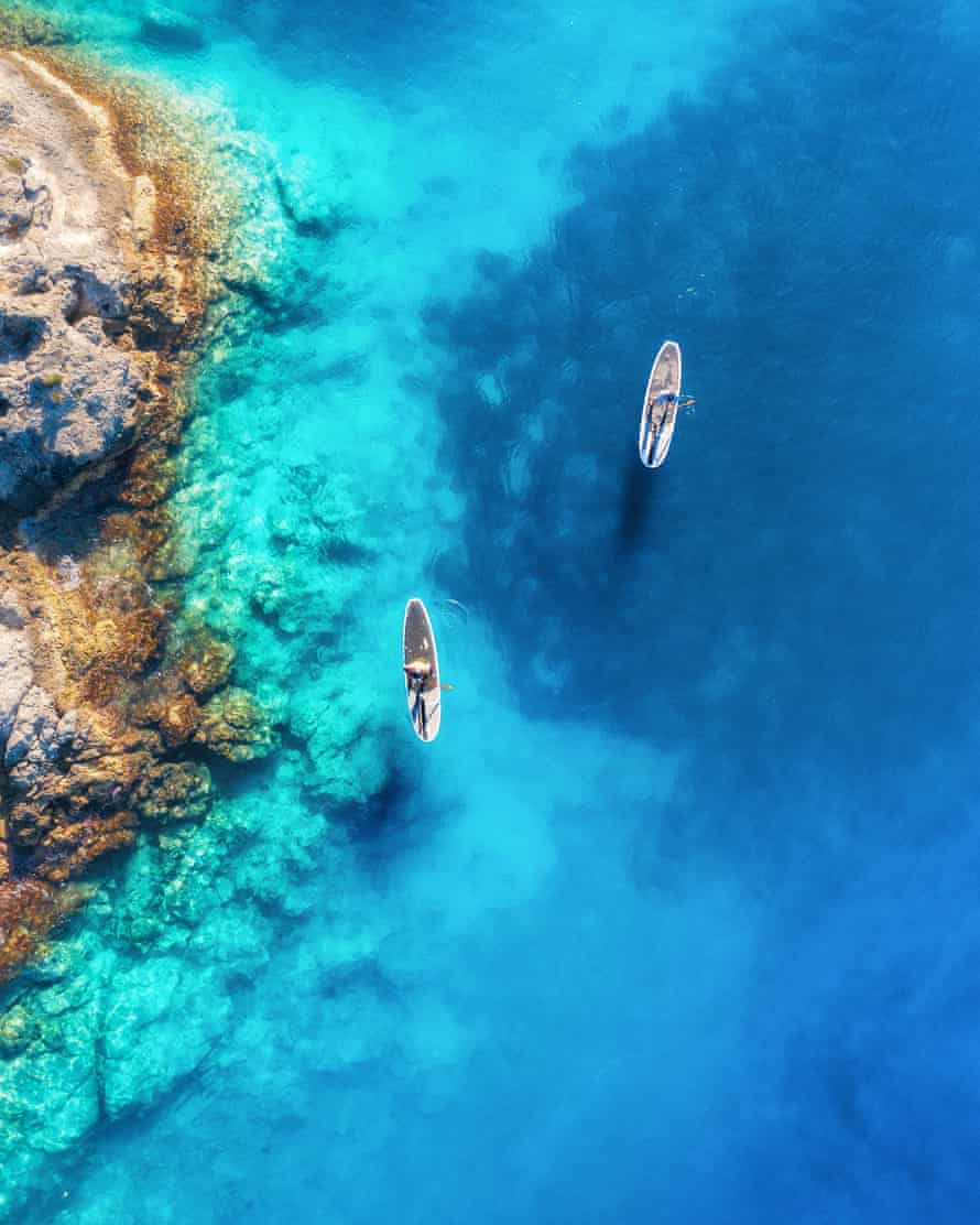 Luftbild von Paddleboardern am blauen Meer.