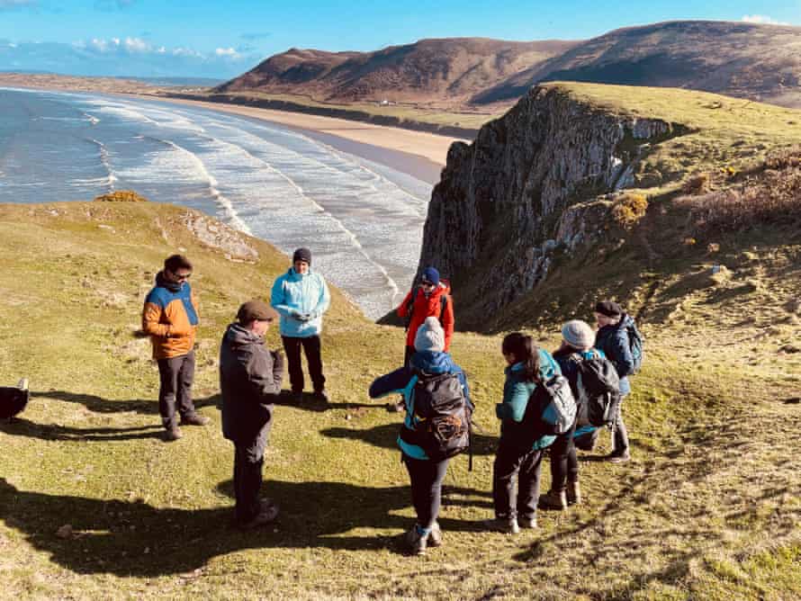 Gruppe auf Spaziergang an der Küste von Wales