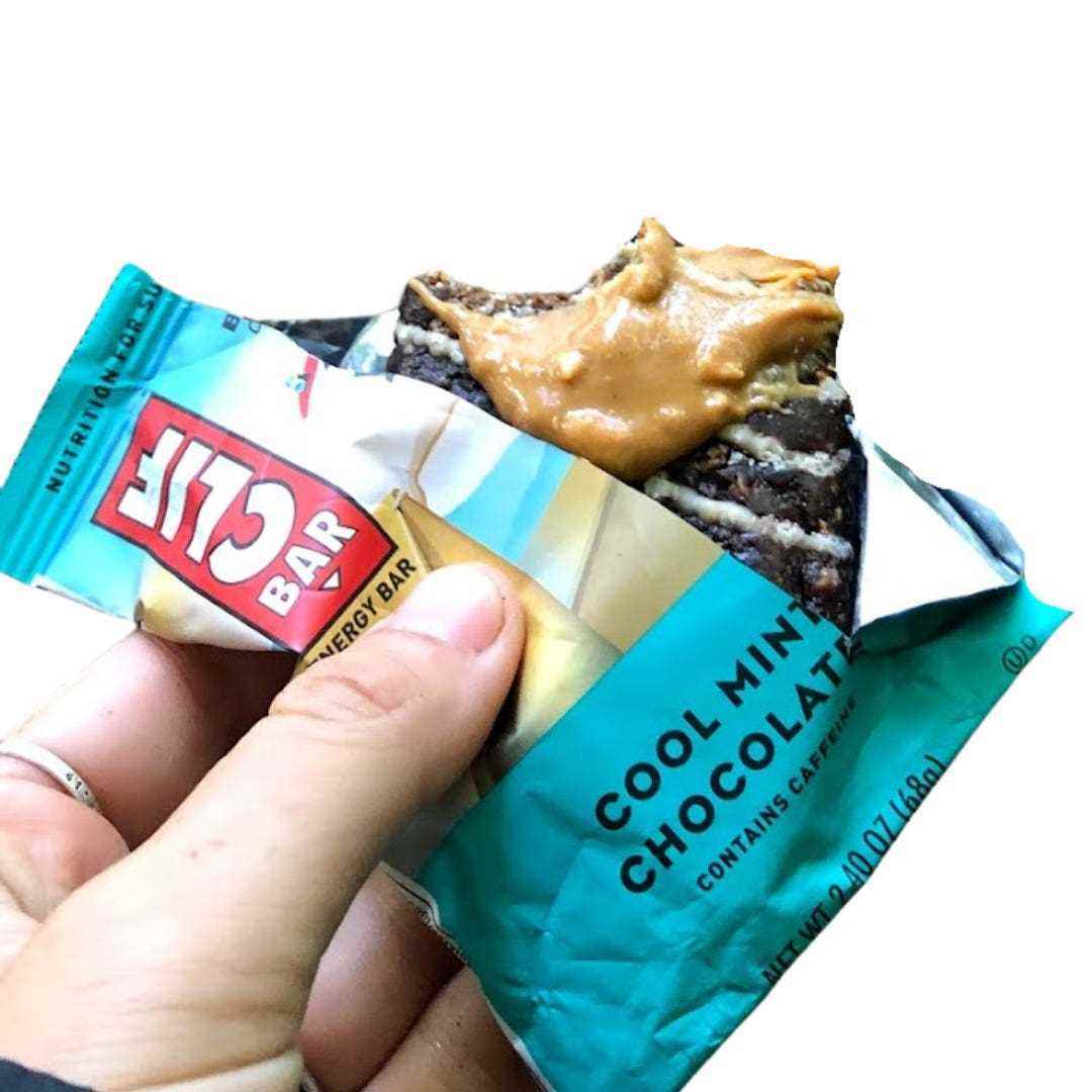 Der Schriftsteller hält einen halb aufgegessenen Clif-Riegel mit blauer Verpackung und dem Text „Cool Mint Chocolate“ darauf