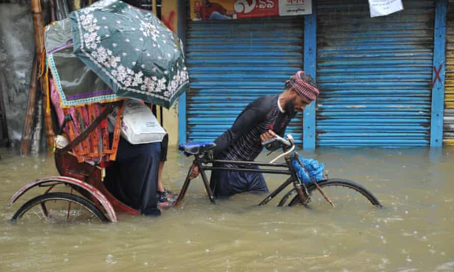 Ein Rikscha-Fahrer navigiert durch eine überflutete Straße in Sylhet, Bangladesch
