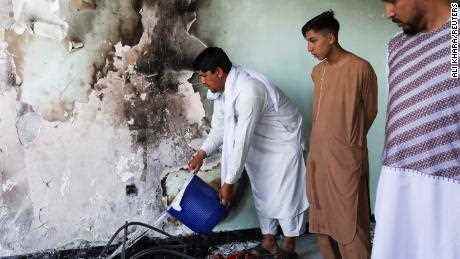 Ein Mann gießt Wasser auf schwelende Asche in einem Haus, das beschädigt wurde, als ein mit Sprengstoff beladenes Fahrzeug inmitten eines Angriffs auf einen Sikh-Tempel in Kabul explodierte. 