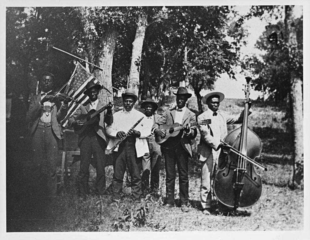 Eine Gruppe von Männern, die verschiedene Instrumente für Juneteenth halten