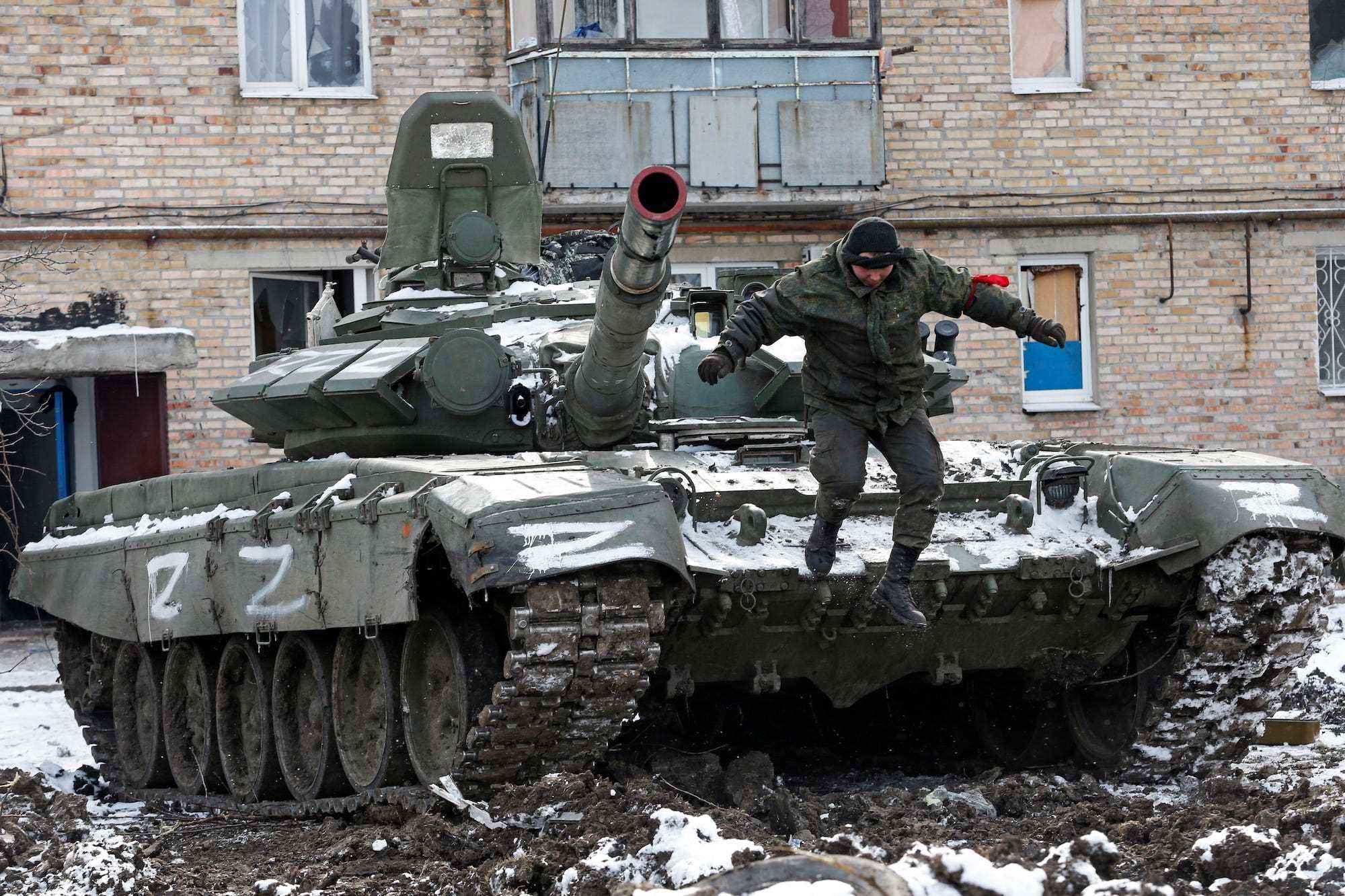 Ein russischer Panzer mit dem Logo „Z“ darauf vor einem Wohngebäude, das während des Konflikts zwischen der Ukraine und Russland in der von Separatisten kontrollierten Stadt Volnovakha in der Region Donezk, Ukraine, am 11. März 2022 beschädigt wurde