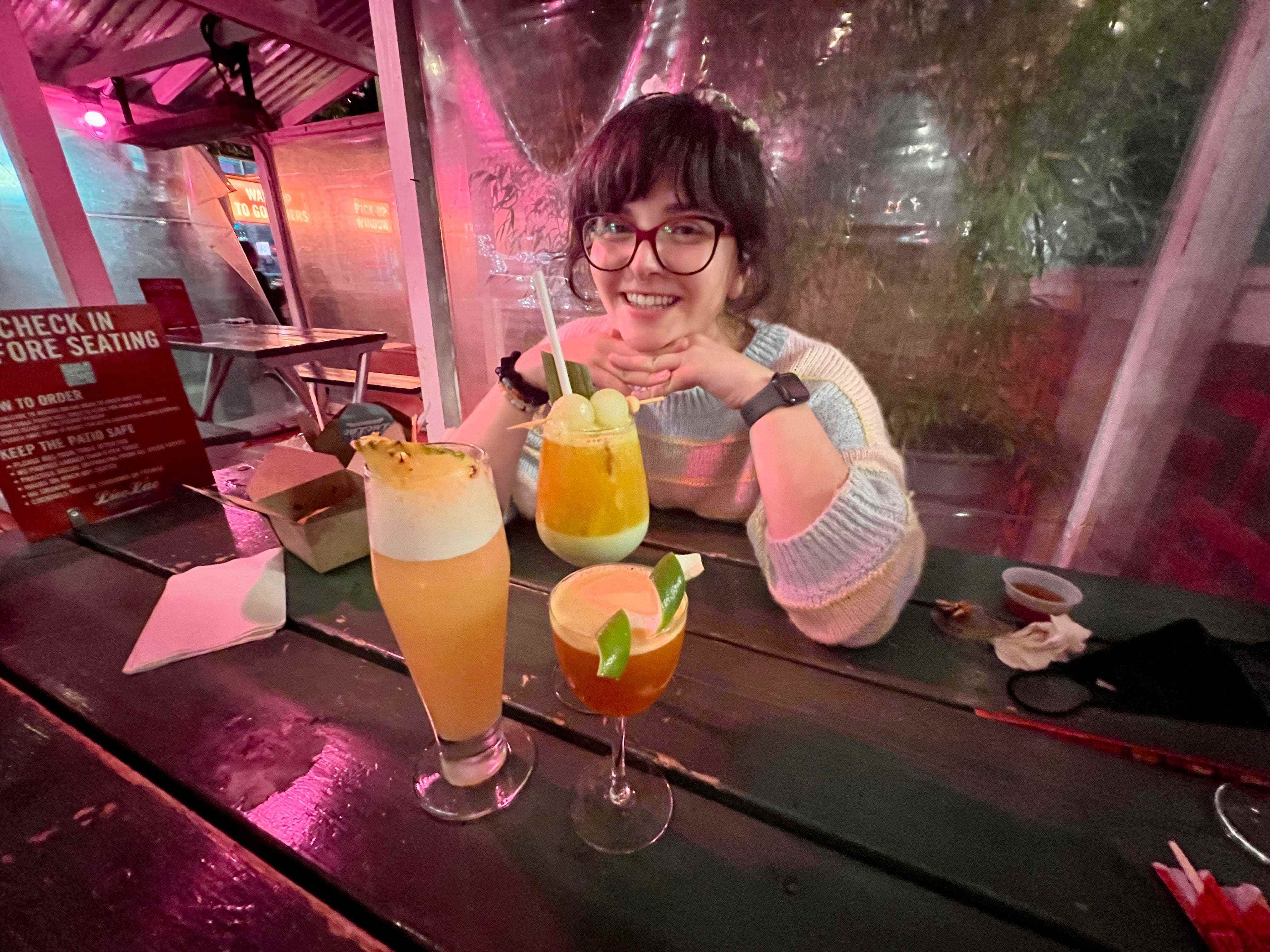 Ashley Probsts Freund lächelt vor drei Cocktails